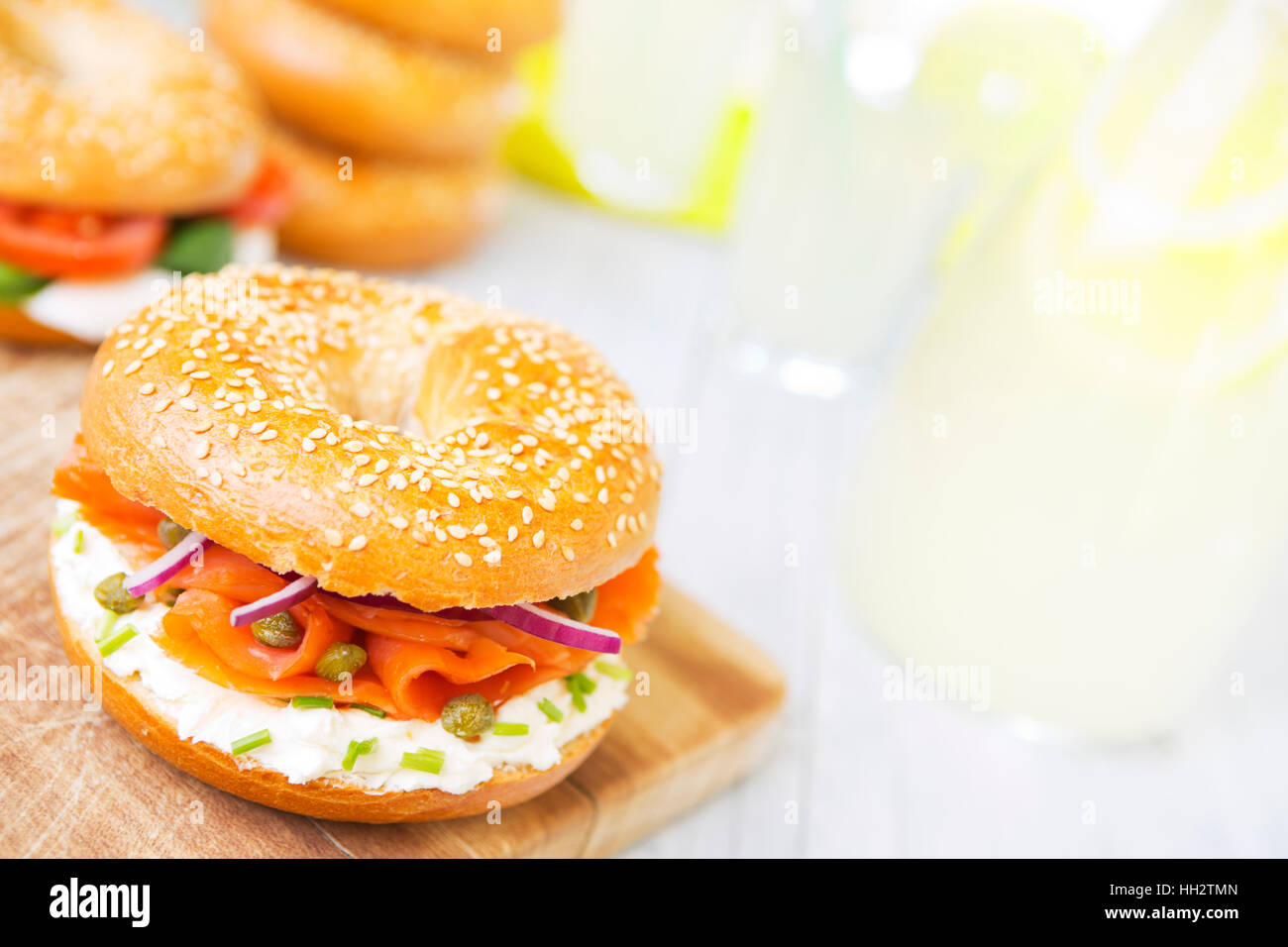 A bagel with salmon, cream cheese and capers. Photographed in bright light with a shallow depth of field. Stock Photo