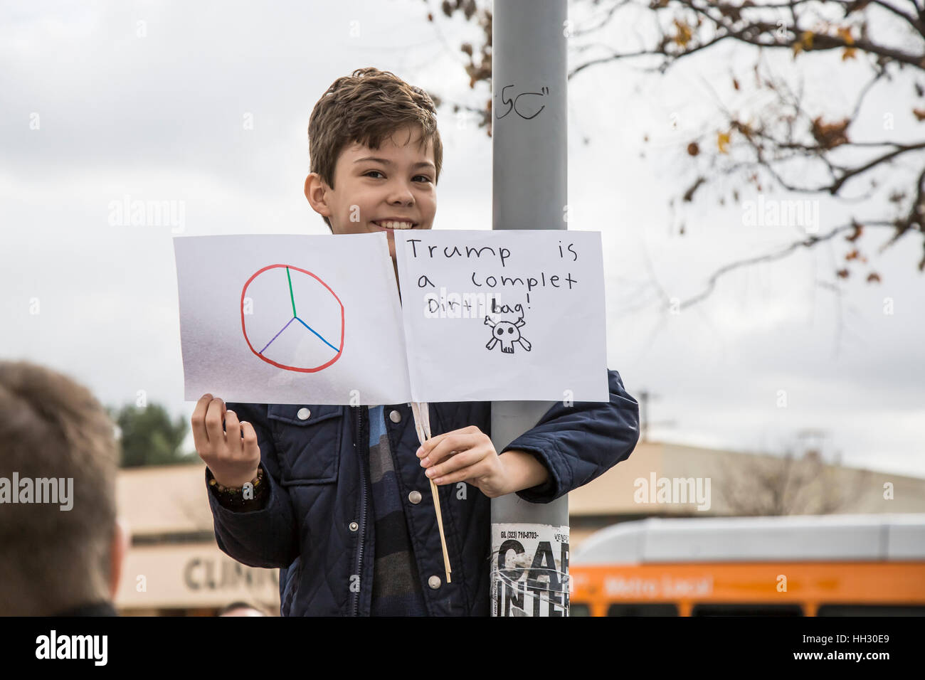 Los Angeles, USA. 15th Jan, 2017. A young boy holds his homemade signs – one for peace and one stating 'Trump is a complet (sic) Dirt-bag!' – at the Los Angeles rally to save the Affordable Care Act at LAC/USC Medical Center. Credit: Andie Mills/Alamy Live News. Stock Photo