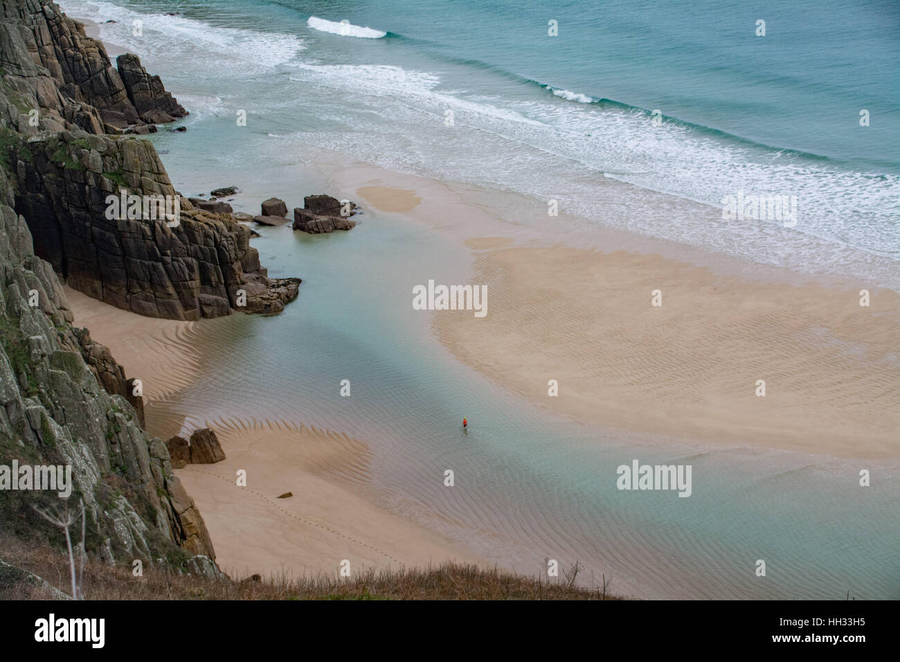 Treen, Cornwall, UK. 16th Jan, 2017. UK Weather. With temperatures of around 10 degrees C, and sheltered from the northerly wind, a sole swimmer makes the most of the blue lagoon formed on the beach at Treen on blue monday. Credit: cwallpix/Alamy Live News Stock Photo