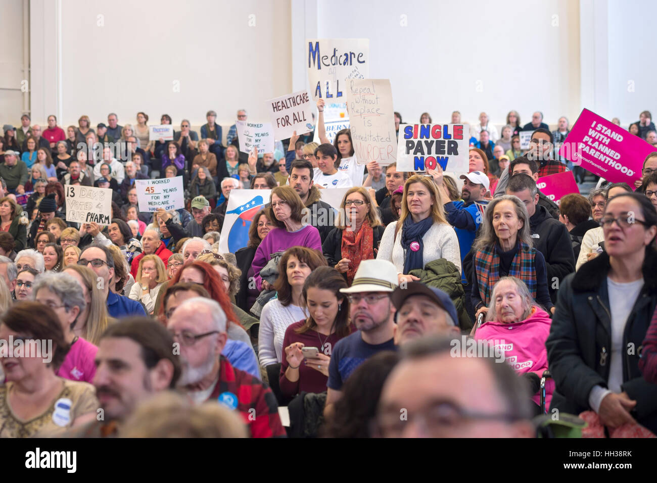 Westbury, USA. January 15, 2017. Hundreds of people, many with protest signs, are in the audience at the 'Our First Stand' Rally against Republicans repealing the Affordable Care Act, ACA. It was one of dozens of nationwide Bernie Sanders rallies for health care that Sunday. Credit: Ann E Parry/Alamy Live News Stock Photo