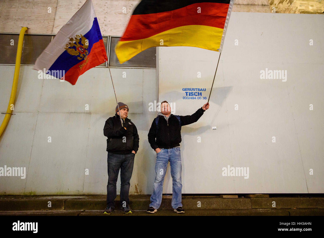 Berlin, Germany. 16th Jan, 2017. Two supporters of the Baergida (Berlin Patriots Against the Islamization of the Occident) group standing with a Russian (l) and a German flag during a demonstration at Breitscheidplatz in Berlin, Germany, 16 January 2017. Photo: Gregor Fischer/dpa/Alamy Live News Stock Photo