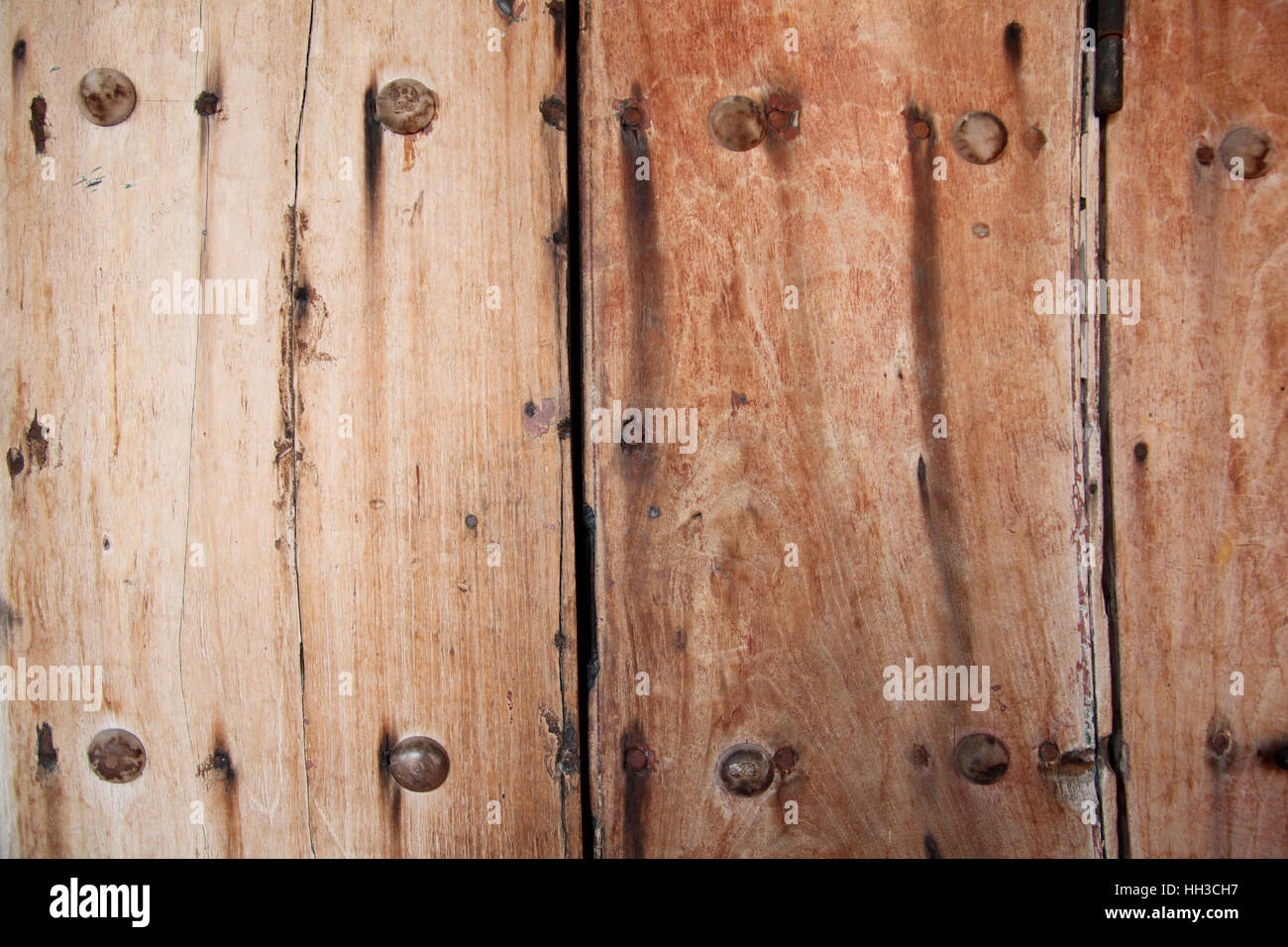 Worn, weathered wooden door or gate with strong & secure metal nails through it, Cartagena, Colombia, South America. Stock Photo