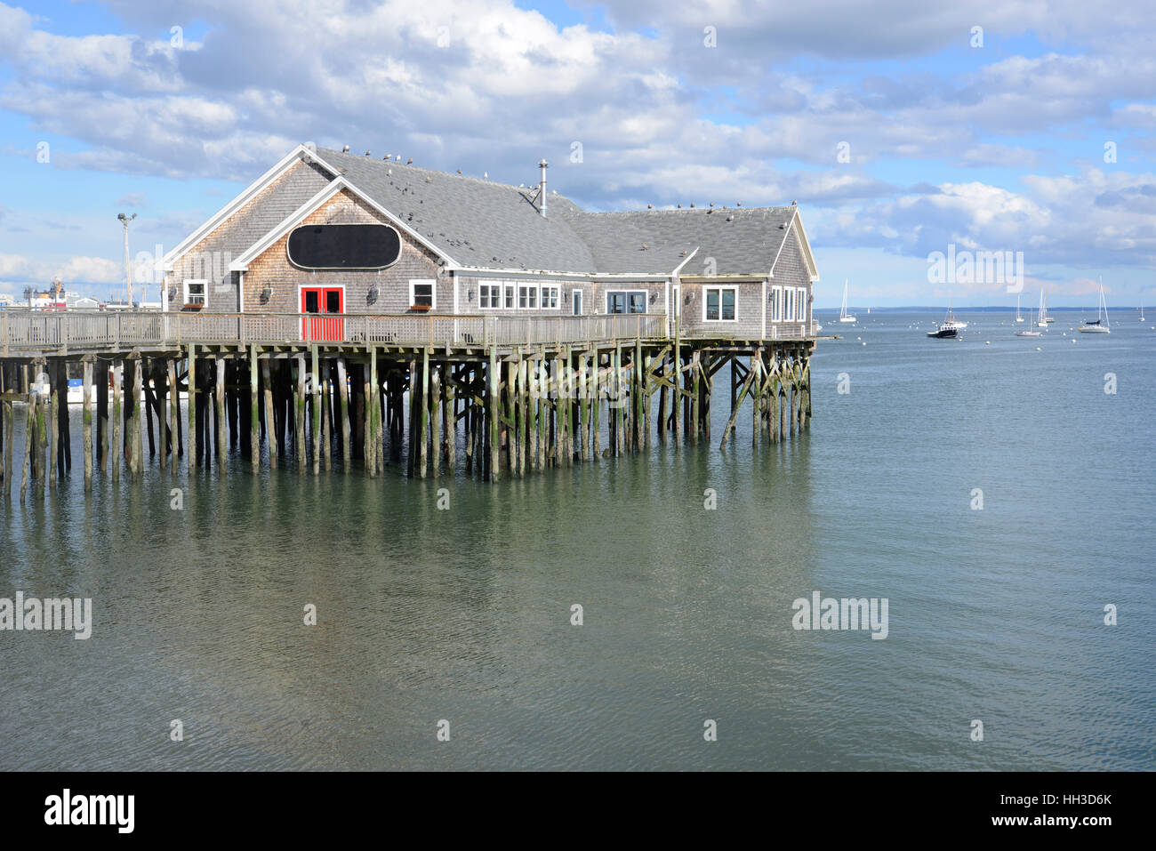 wood building on logs over water at low tide Stock Photo