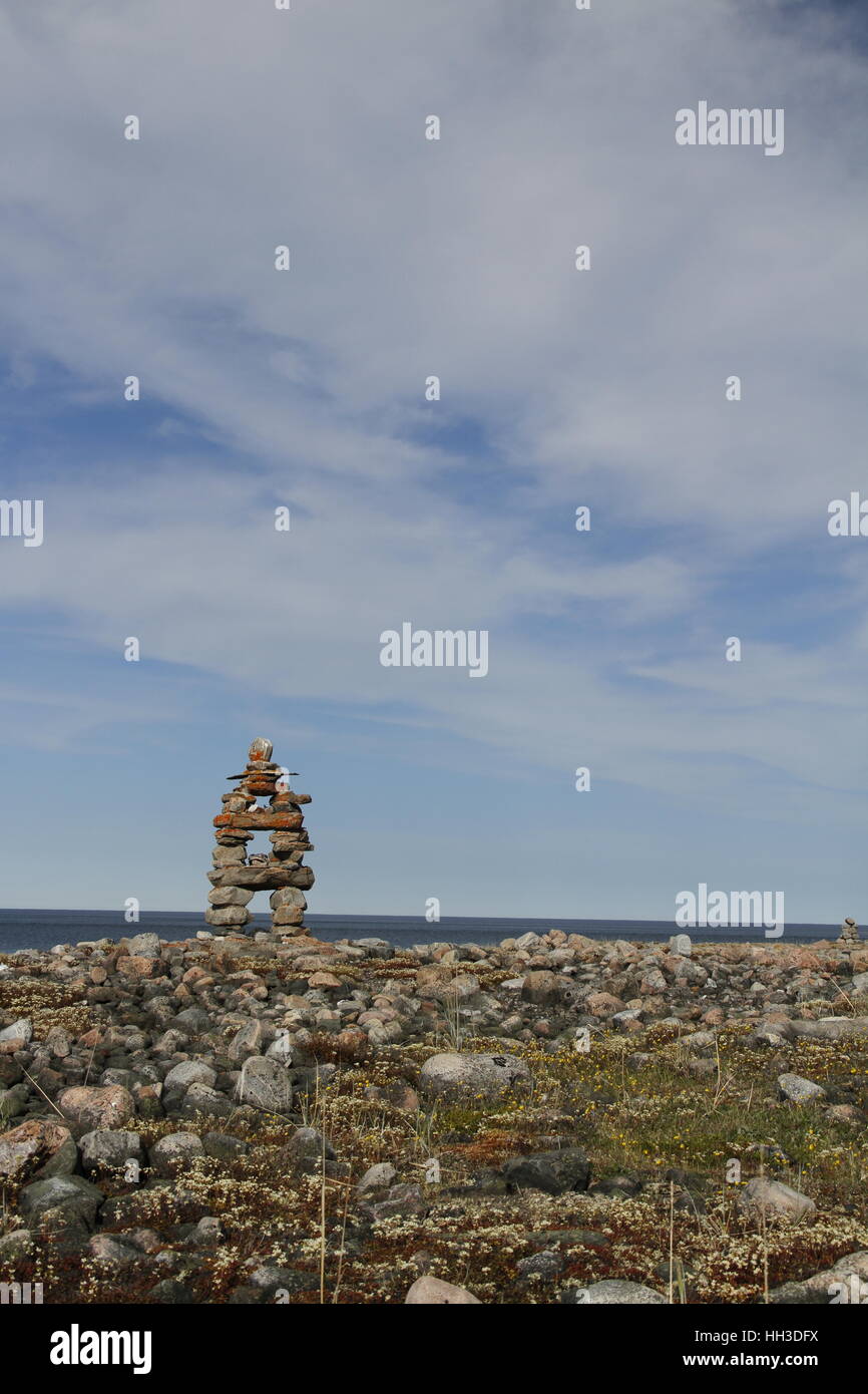 Traditional Inuit landmark (Inukshuk or Inuksuk) near Arviat, Nunavut on the Hudson Bay shoreline Stock Photo