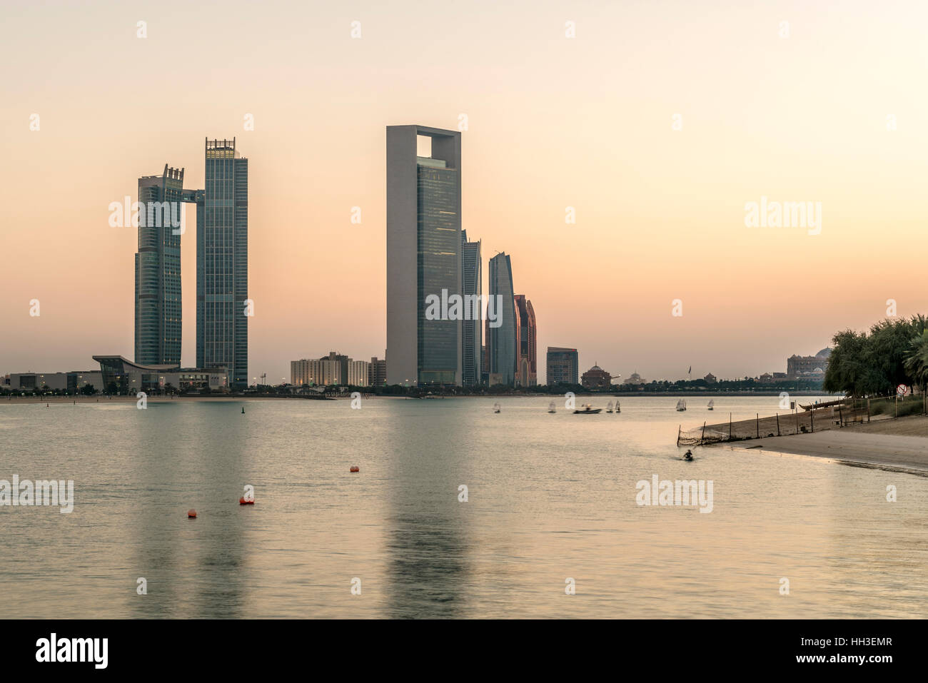 Abu Dhabi Corniche sunset.  Dusk over the coastline and the corniche with Etihad Towers on the skyline Stock Photo