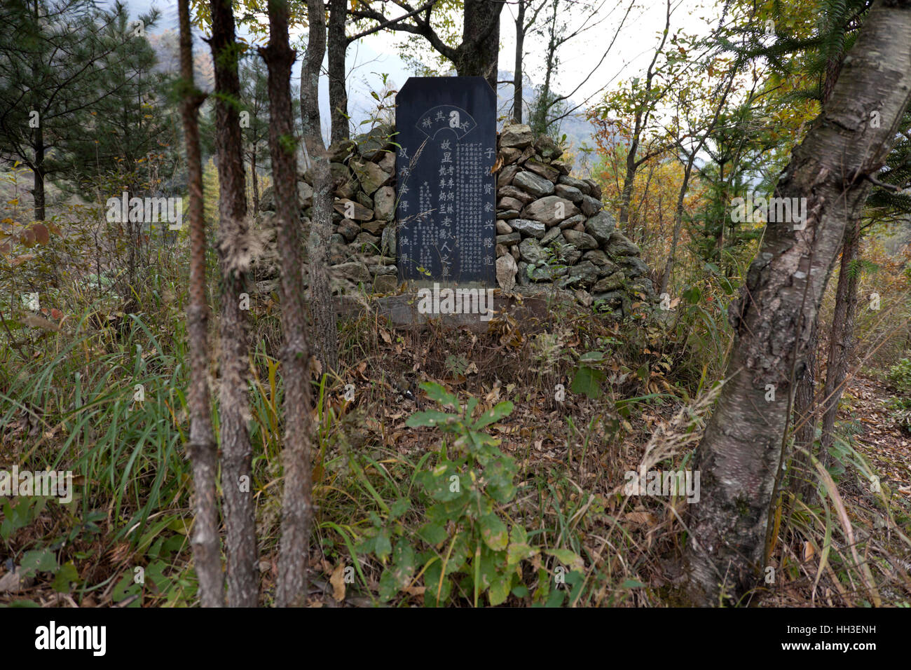 The dead in rural parts of China are still interred in mounds of rocks and earth which is then fronted by a tombstone. Stock Photo