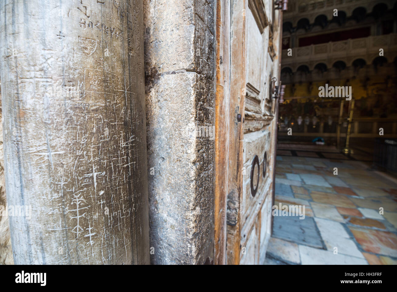 Marble pillars and old wooden door at the entrance to the Church of the Holy Sepulchre in Jerusalem, Israel Stock Photo