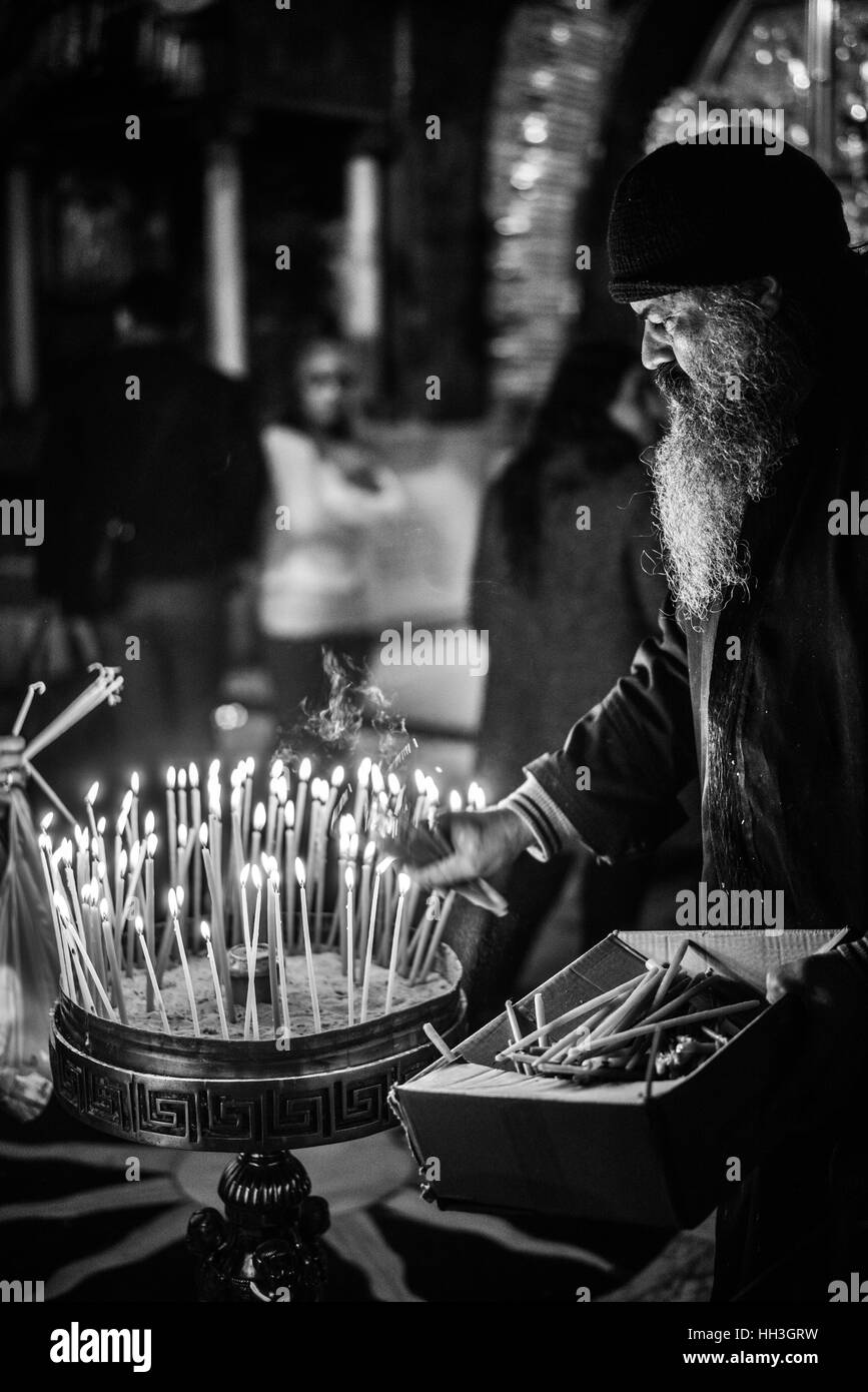 A Greek Orthodox cleric in the Crucifixion altar in the Church of Holy Sepulchre on Golgotha, Jerusalem, Israel Stock Photo