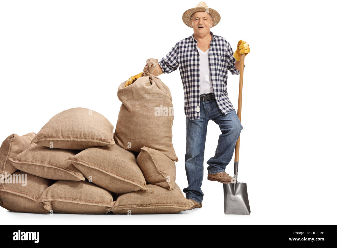 Full length portrait of a happy elderly farmer with a shovel standing ...