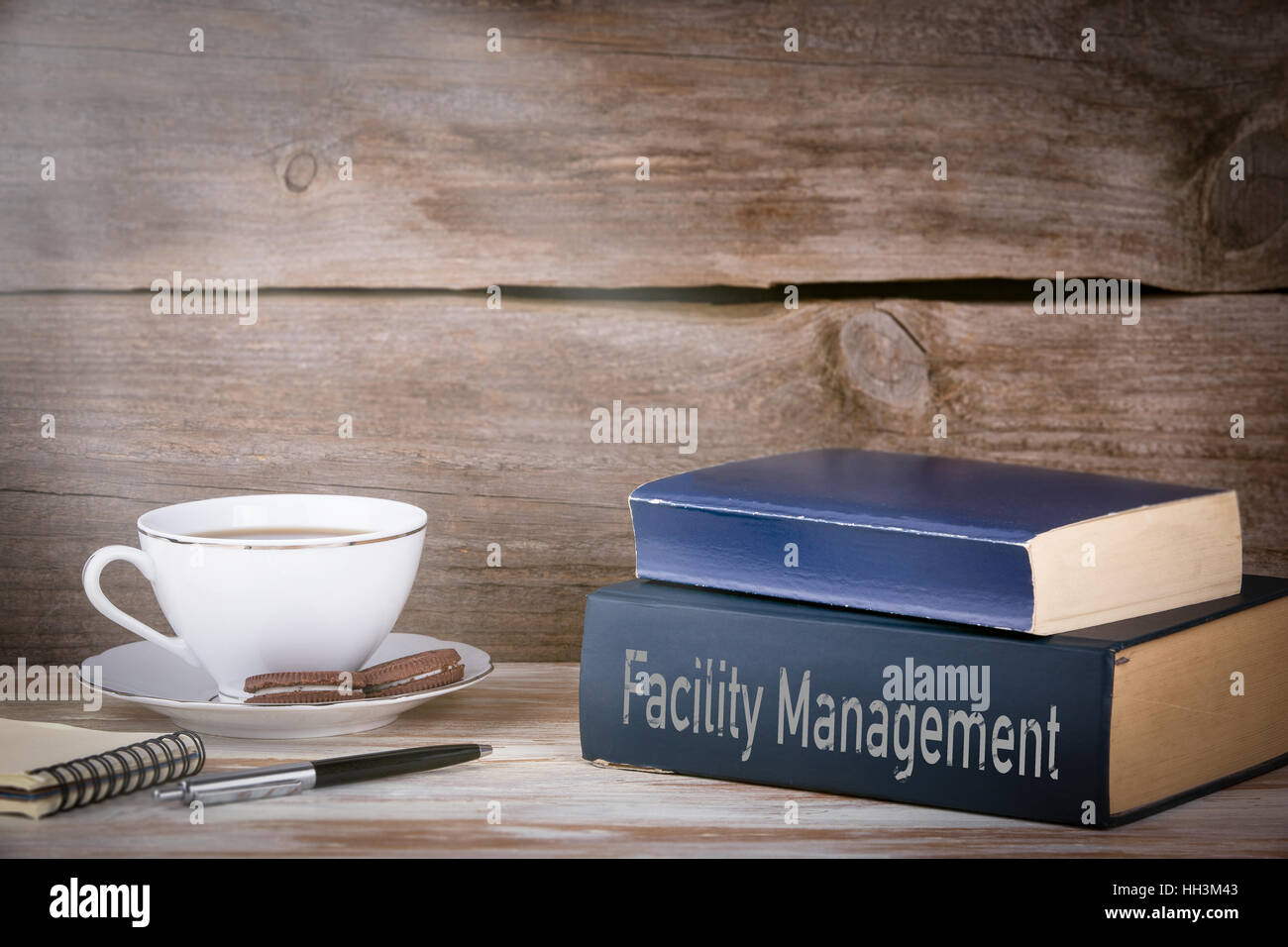 Stack Of Management Books Facility Management. Stack of books on wooden desk Stock Photo - Alamy
