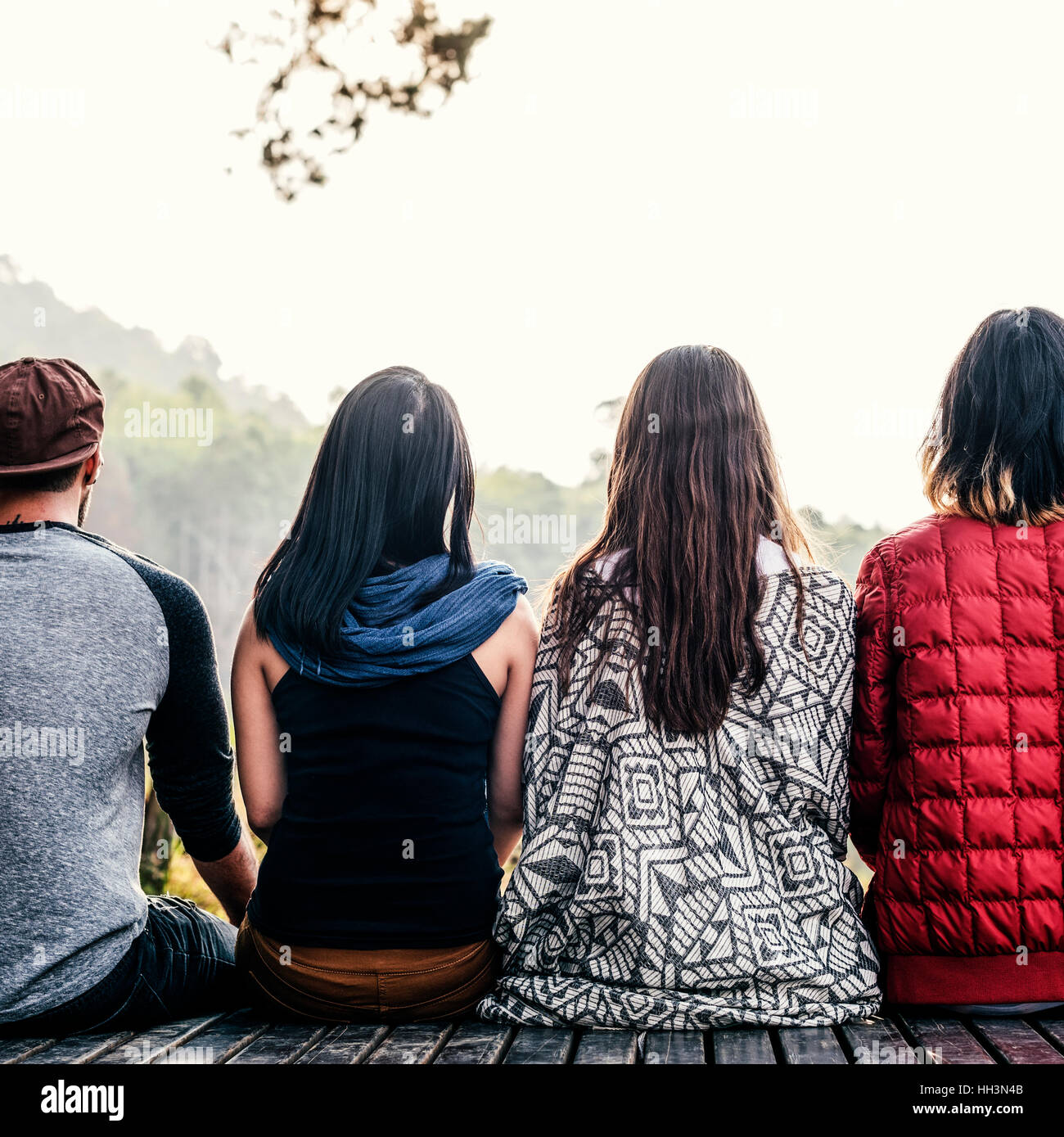 Friends Sitting in a Row Outdoors Concept Stock Photo - Alamy