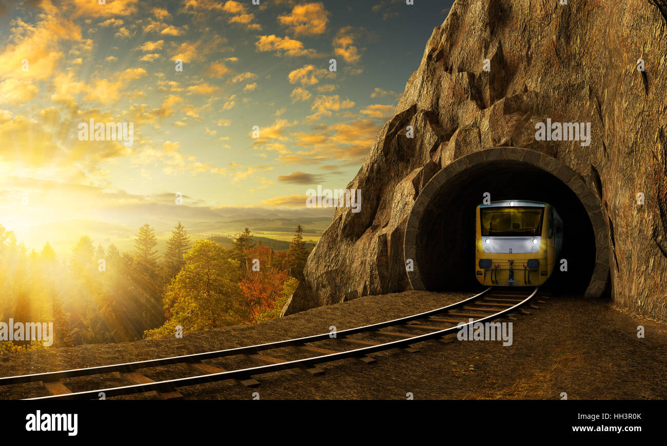 Mountain railroad with train in tunnel. Sunset landscape under the big rock. Stock Photo