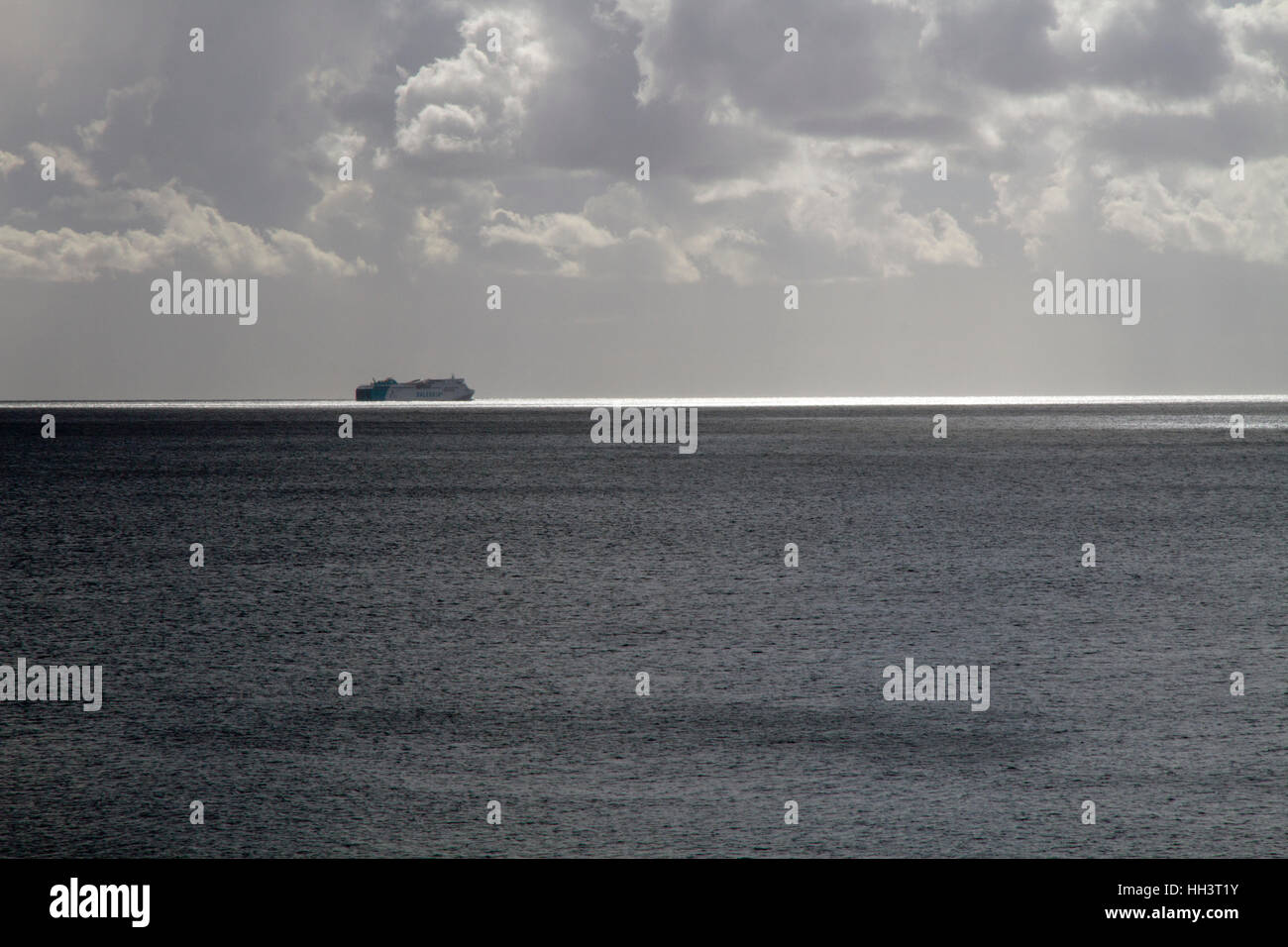 Ferry boat on horizon in Dramatic sea winter cloudy day light scene, Mallorca Spain Stock Photo