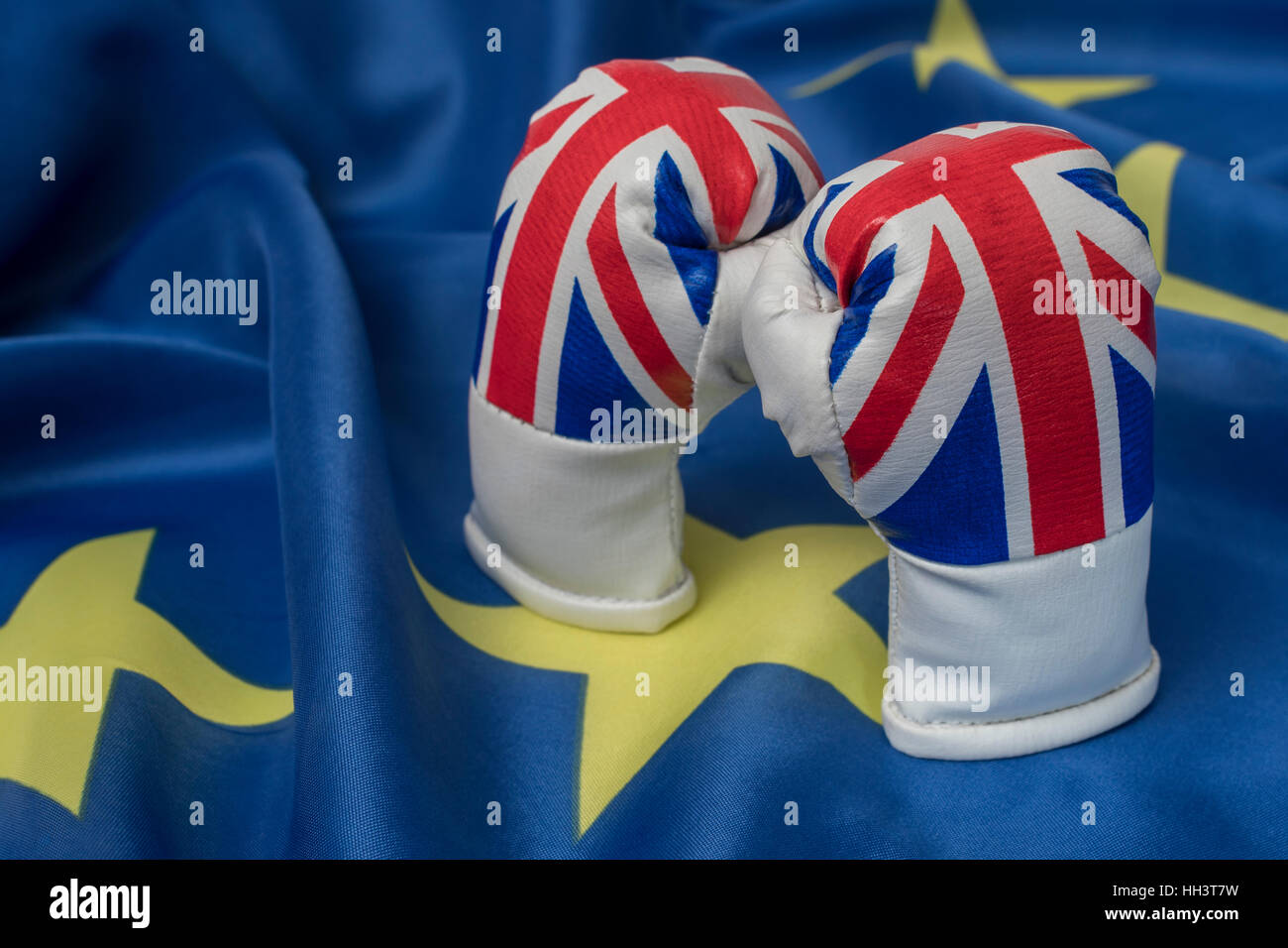 Union Jack boxing gloves blue background & yellow stars (like EU flag). Concept UK trade / Brexit negotiations,  EU UK relationship, gloves are off Stock Photo
