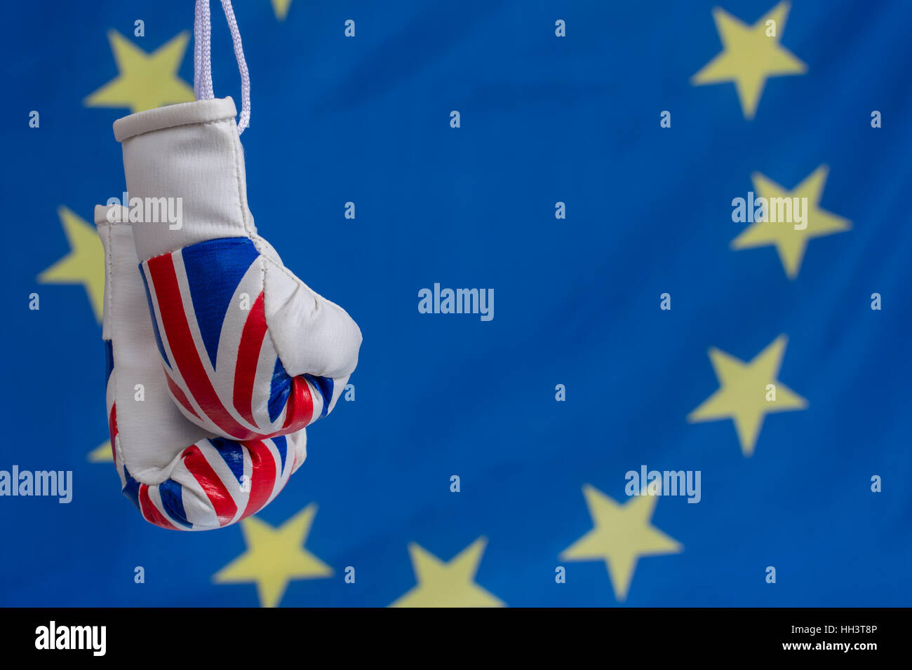 Union Jack boxing gloves blue background & yellow stars (like EU flag). Concept UK trade / Brexit negotiations,  EU UK relationship, gloves are off Stock Photo