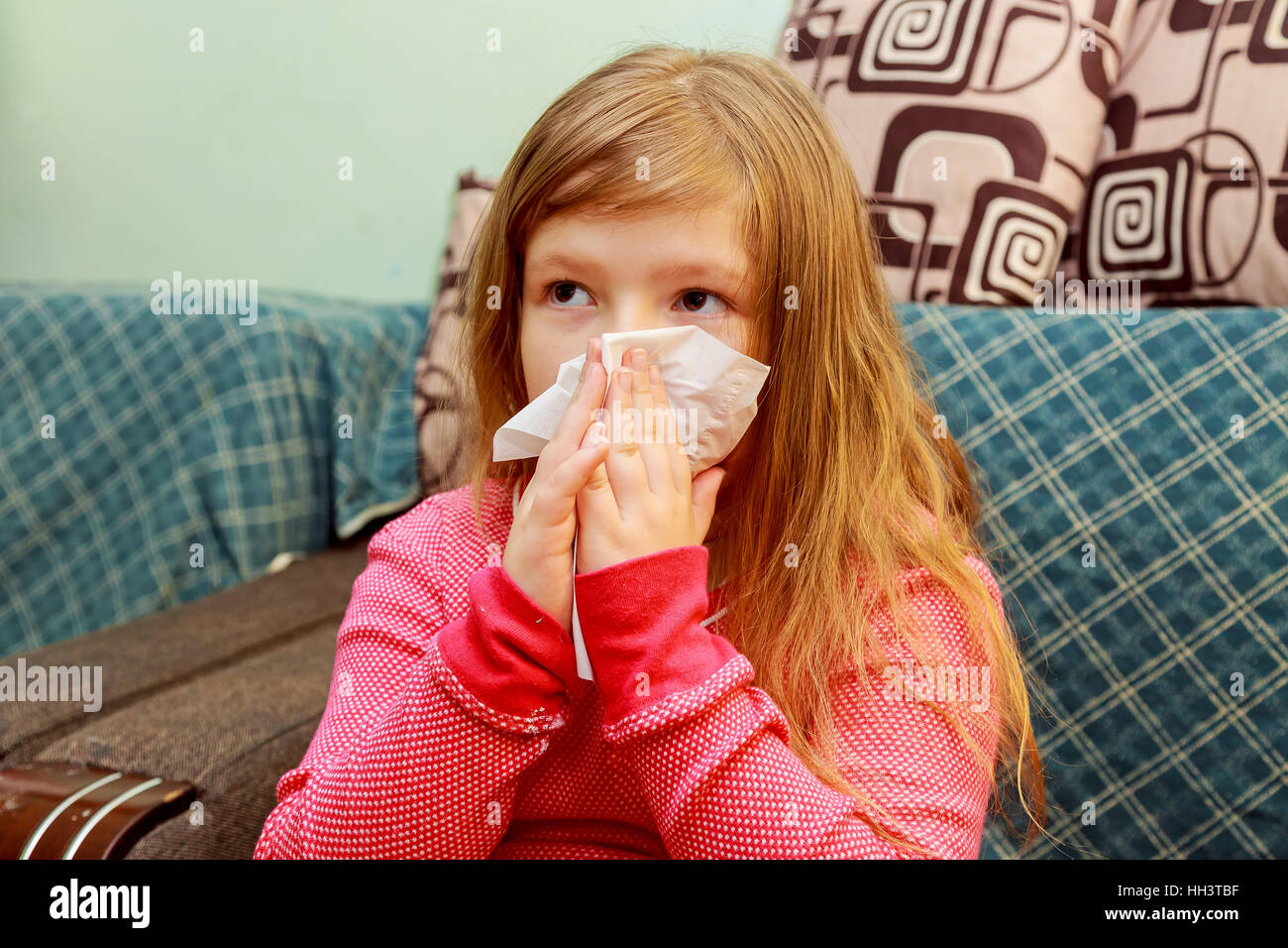 Little girl blows his nose in a paper tissue sick child wiping his nose