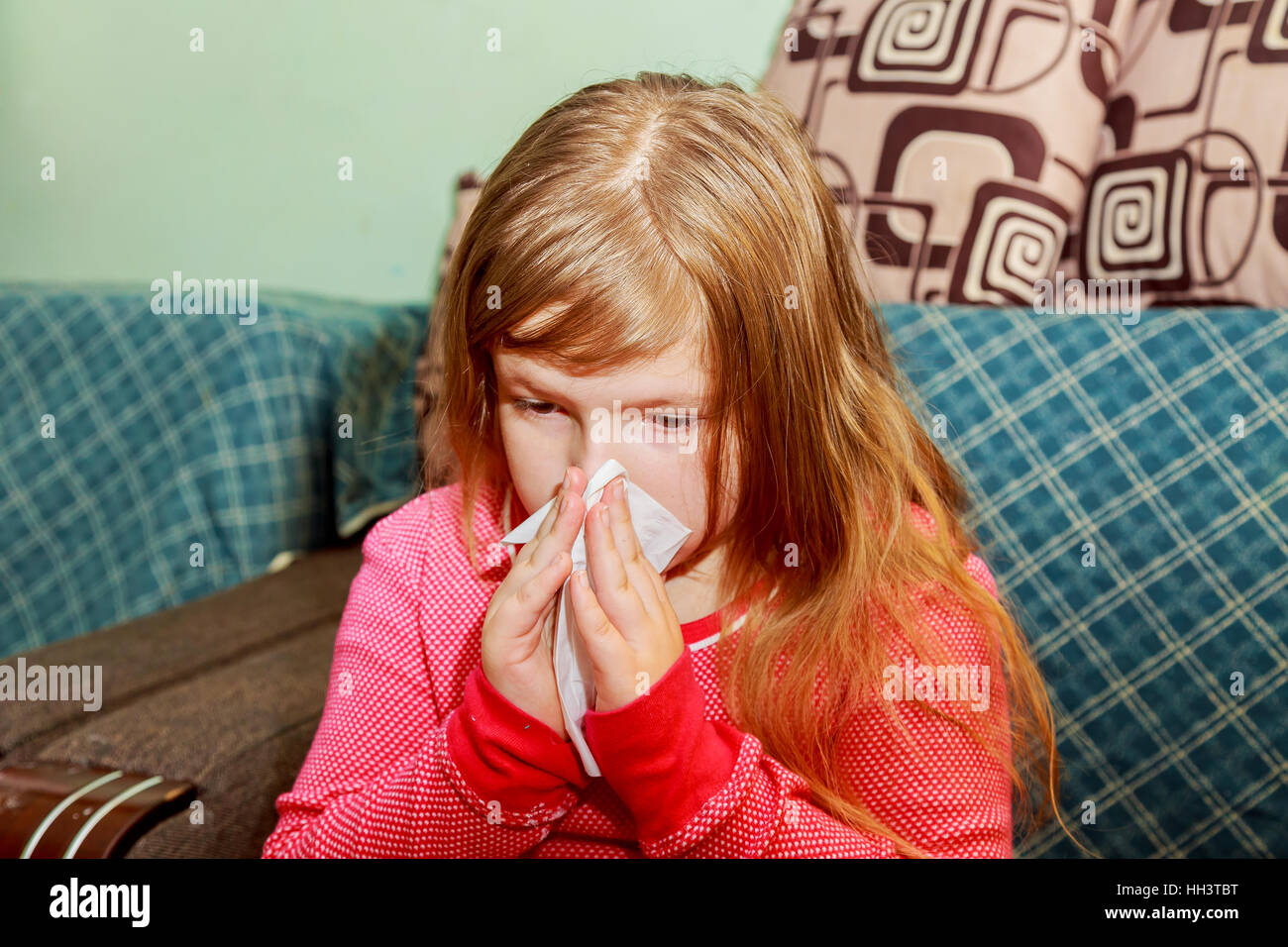 Little girl blows his nose in a paper tissue sick child wiping his nose