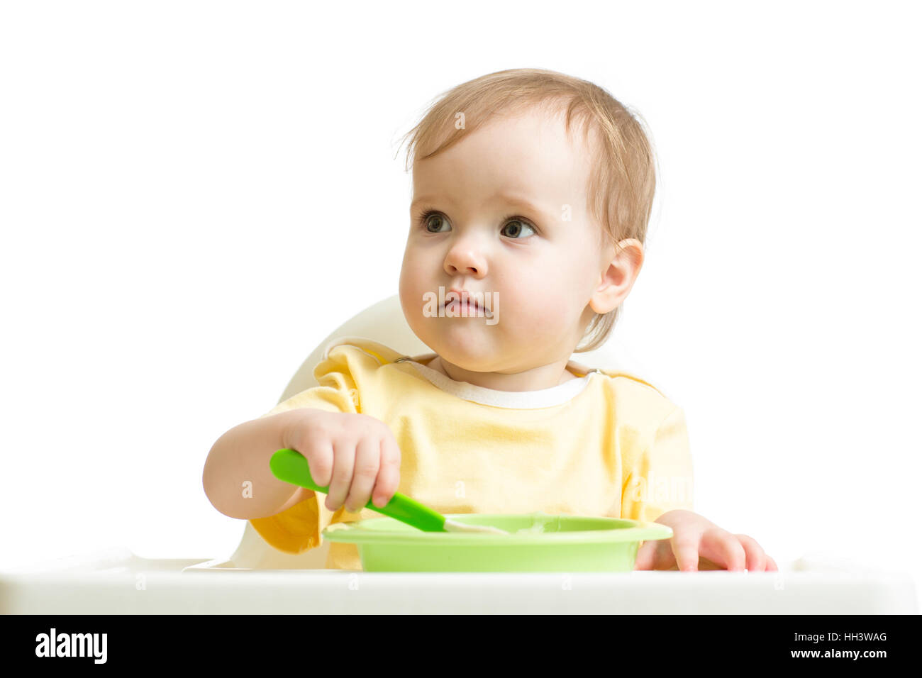 Baby girl eating yogurt or puree isolated on white Stock Photo
