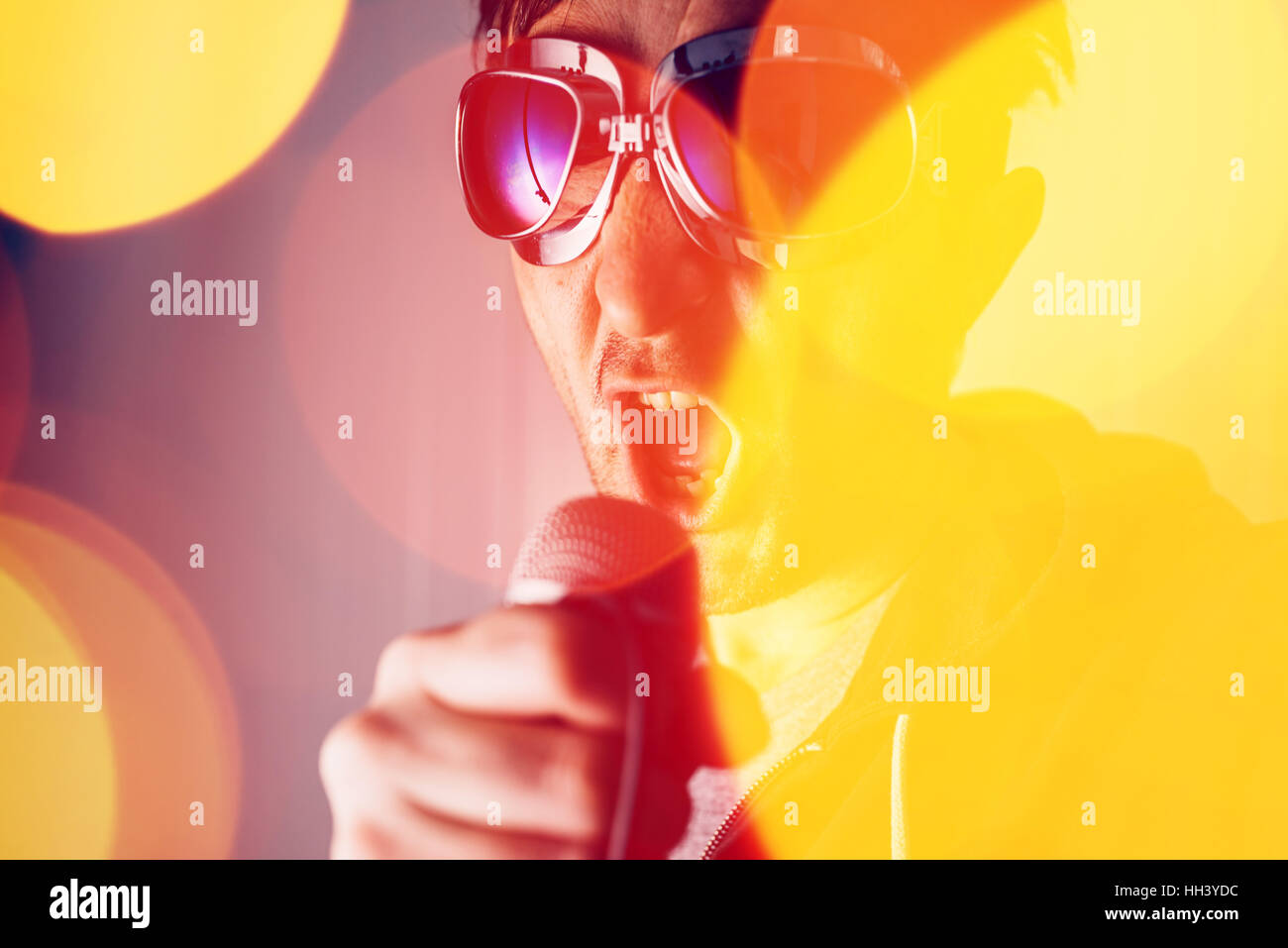Alternative rock music singer singing song into microphone, bokeh light