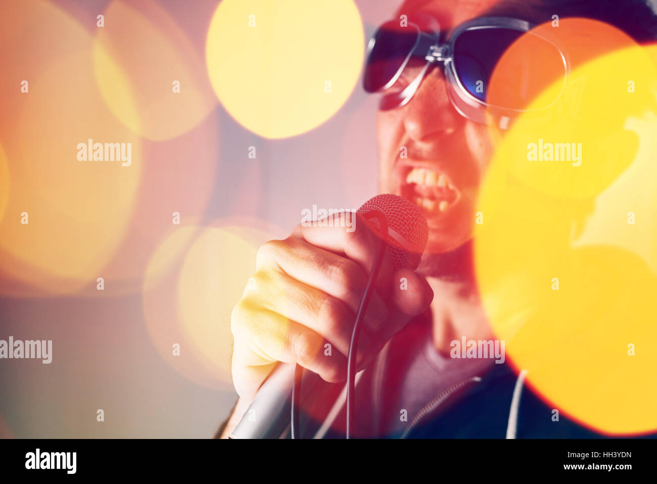 Alternative rock music singer singing song into microphone, bokeh light