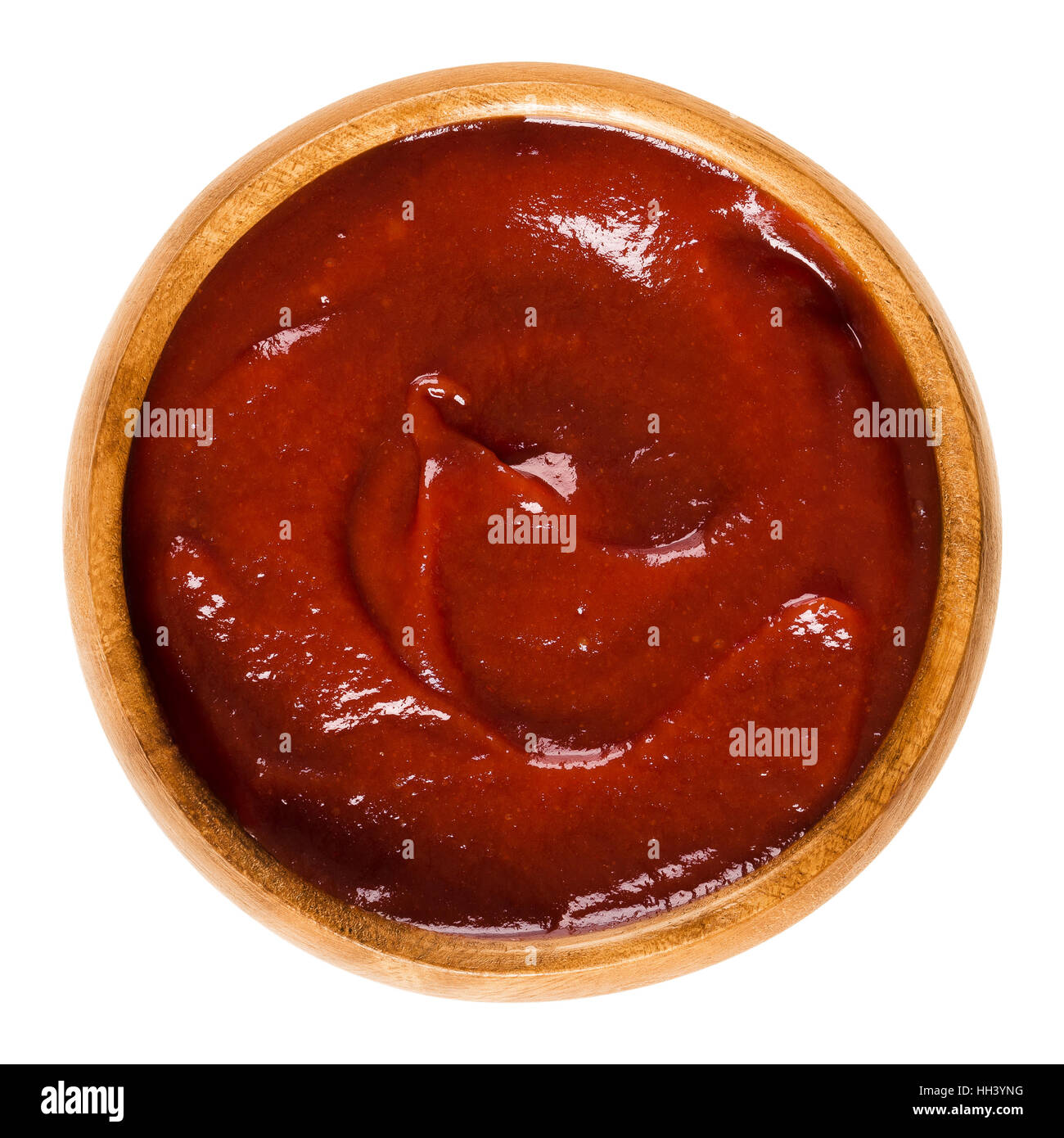 Tomato ketchup in wooden bowl. Also called catsup or ketsup, is a red table sauce made from tomatoes, often used as a condiment. Stock Photo