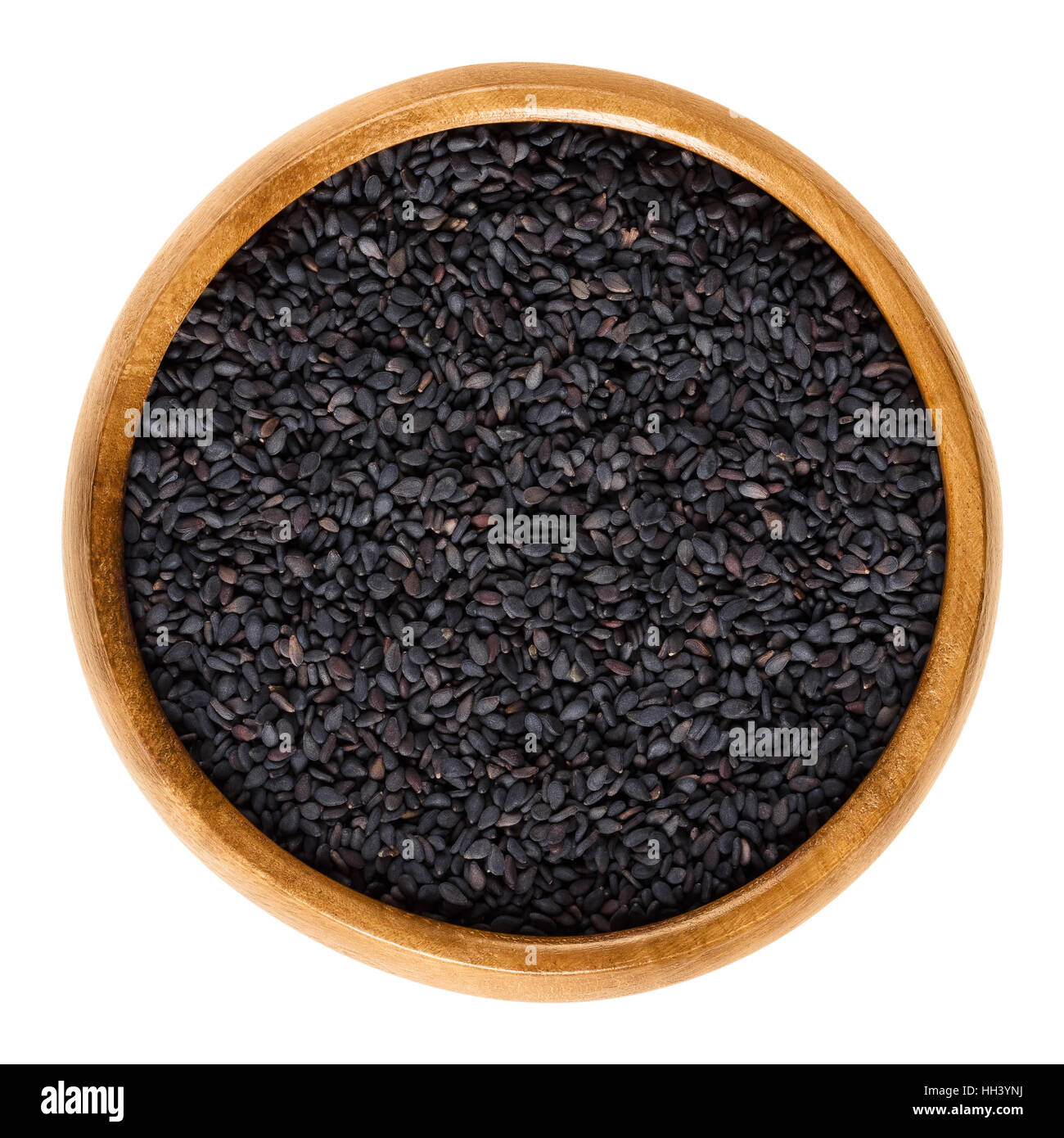 Black sesame seeds in wooden bowl. Fruits of Sesamum radiatum, also black benniseed or vegetable sesame. Stock Photo