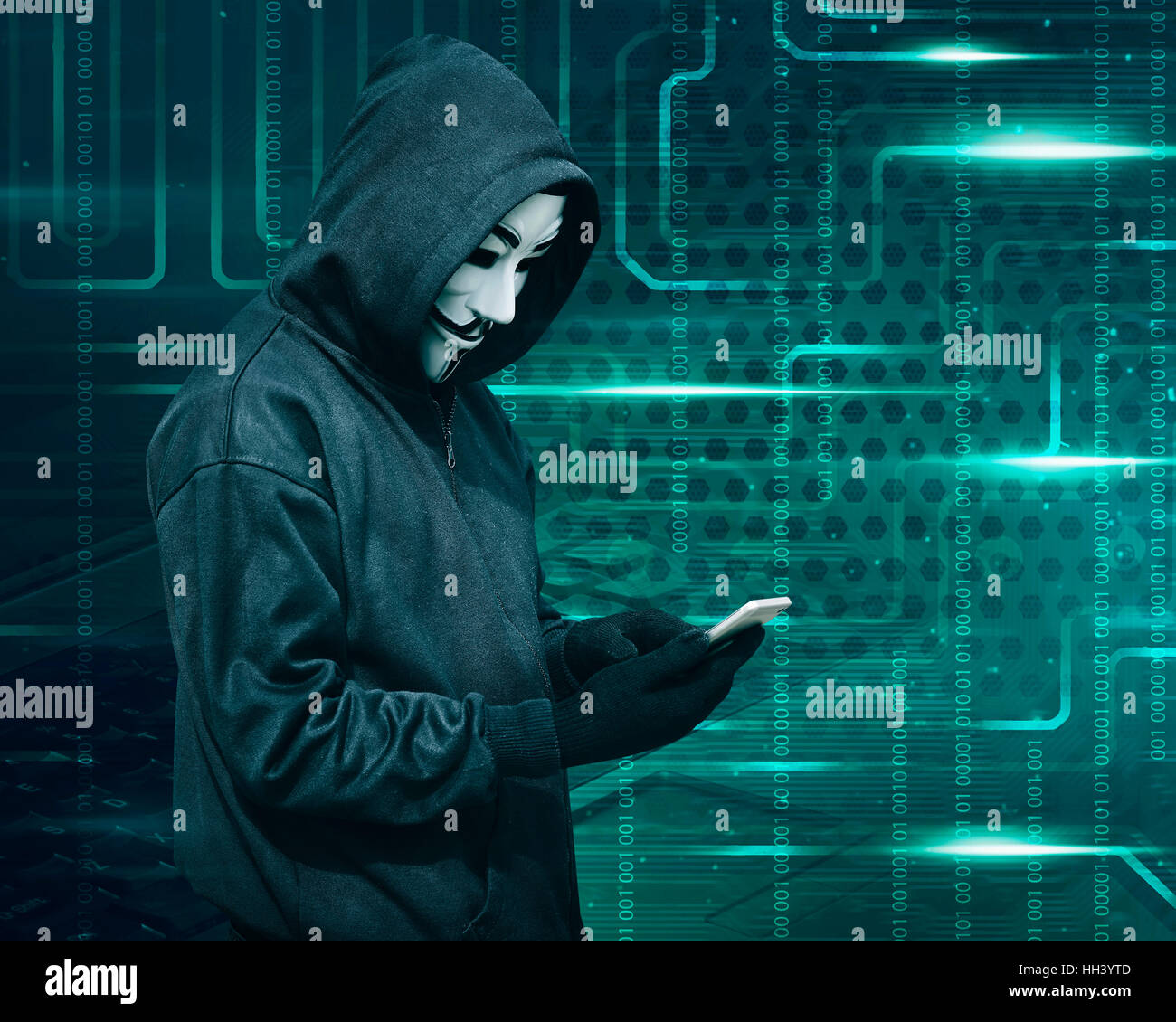 Hacker with mask touching a smartphone screen against binary code ...