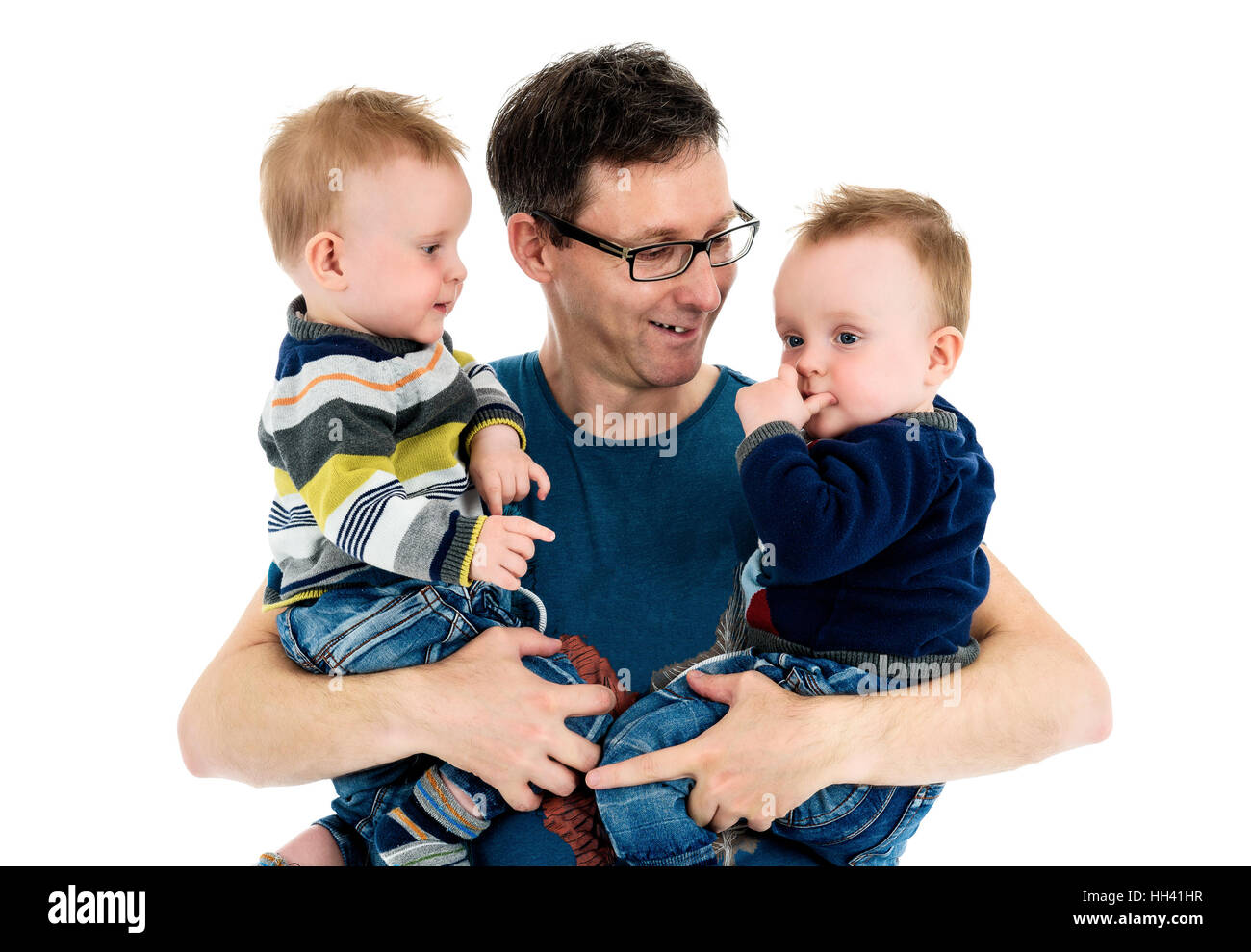 Proud Father is holding his twin sons in his arms. A single parent is carrying his twins and smiling. Isolated on white background. Stock Photo