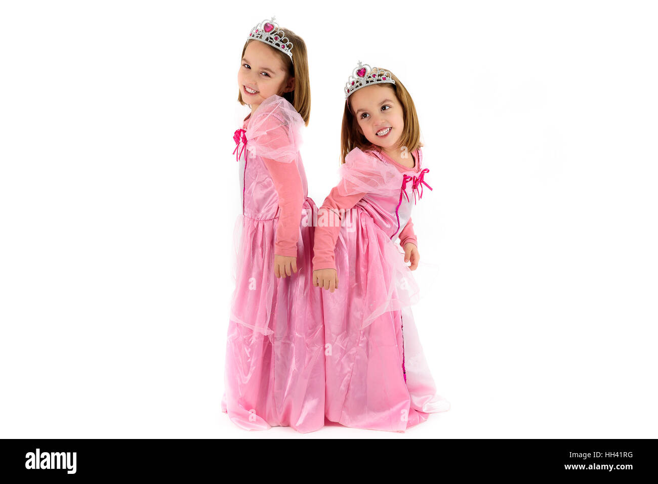 Portrait of Little Twin Girls dressed as princess in pink. Happy
