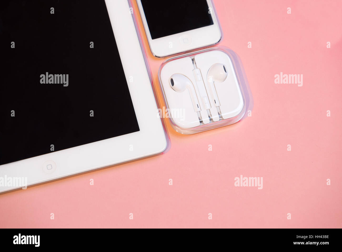 Smart phone, tablet and headphones against pink background Stock Photo