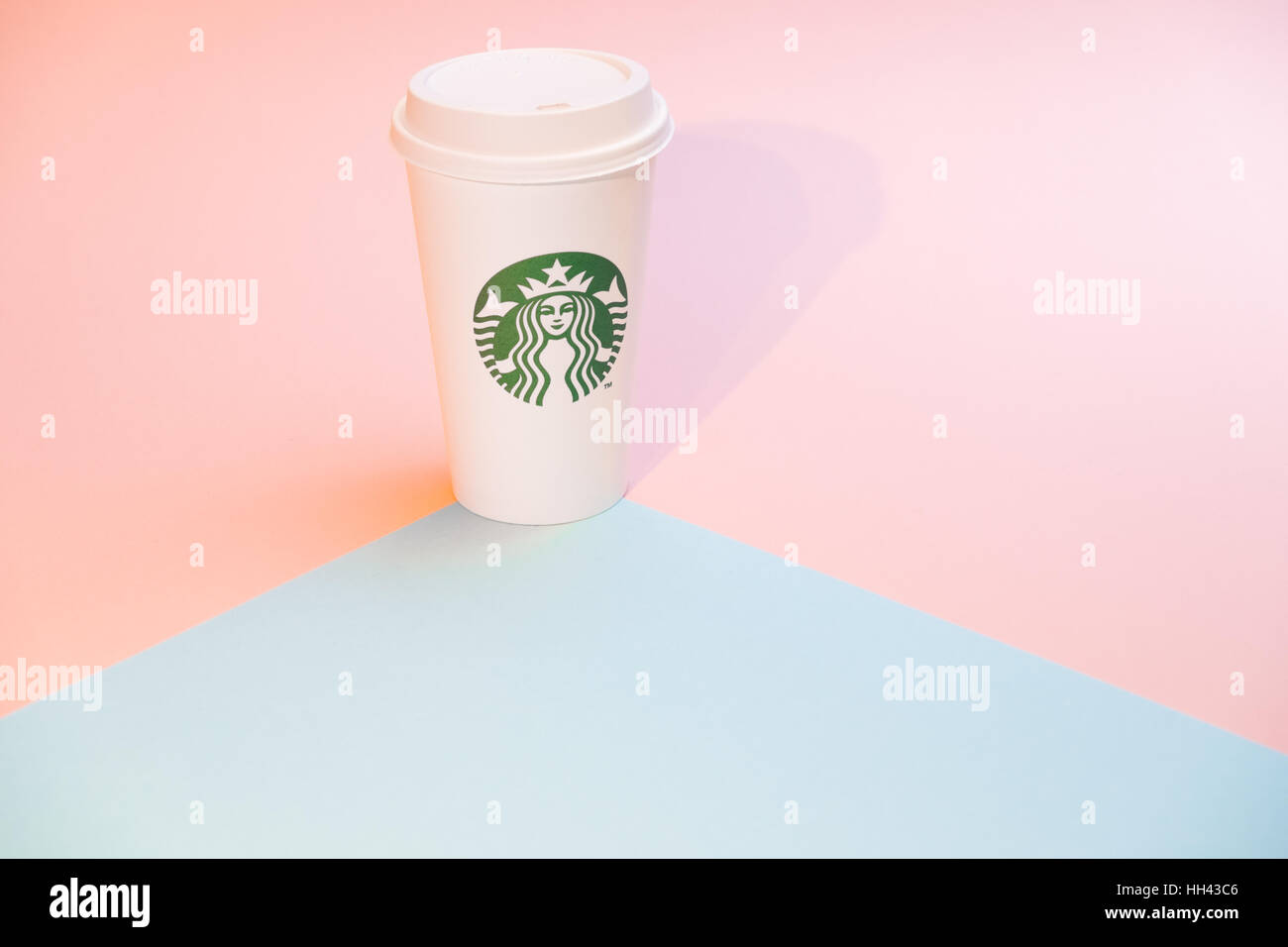 Disposable coffee cup against pink and aqua backdrop Stock Photo
