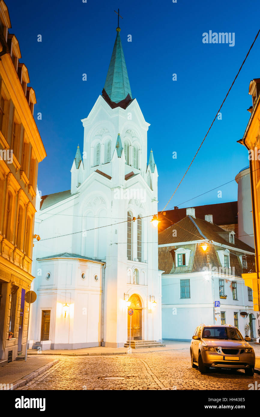 Riga Latvia. The White Tower With Pyramidal Spire Of Our Lady Of Sorrows Or Virgin Of Anguish Church, Ancient Catholic Church On Pils Street In Evenin Stock Photo