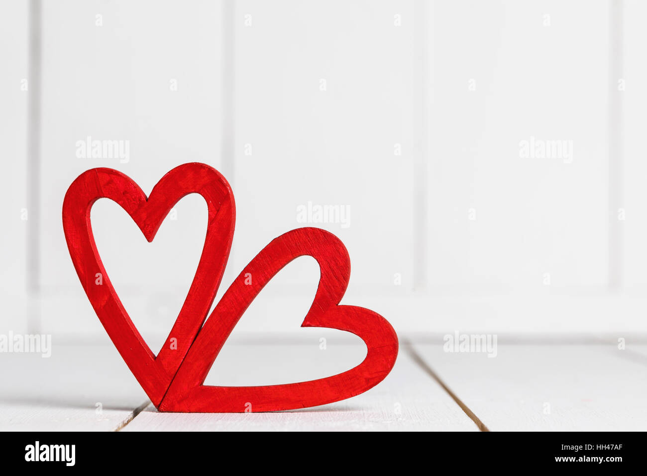 Two red hearts on white wooden background Stock Photo - Alamy