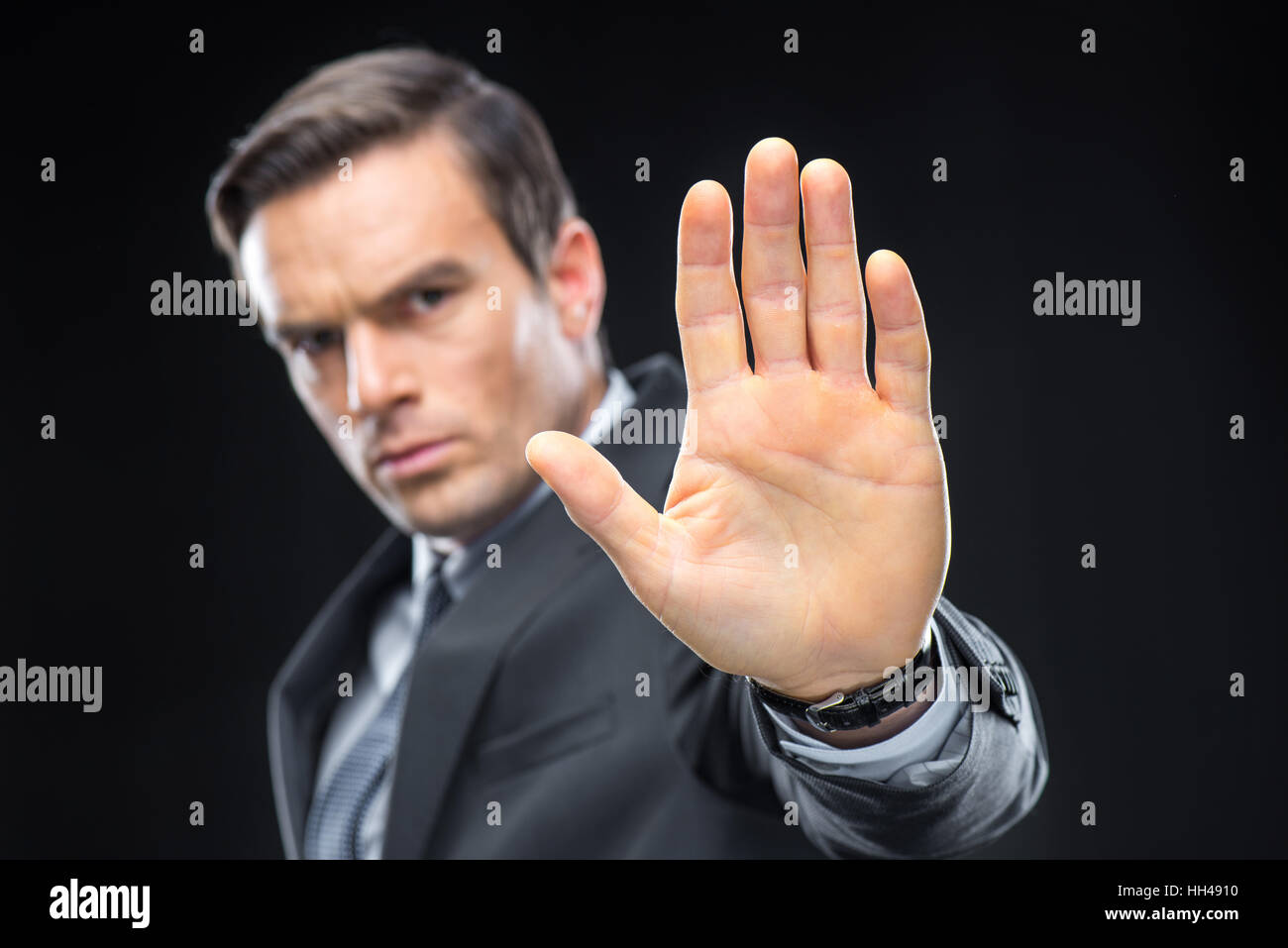 Close-up view of handsome businessman gesturing with palm and looking at camera Stock Photo