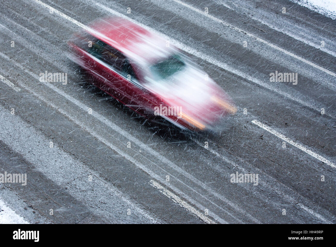 Snowy day in the city: A driving car in the street hit by the heavy ...