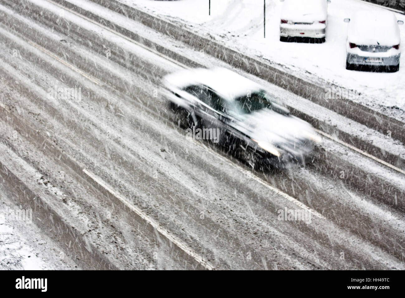 Blurry driving car on the empty city street during a heavy snowfall ...