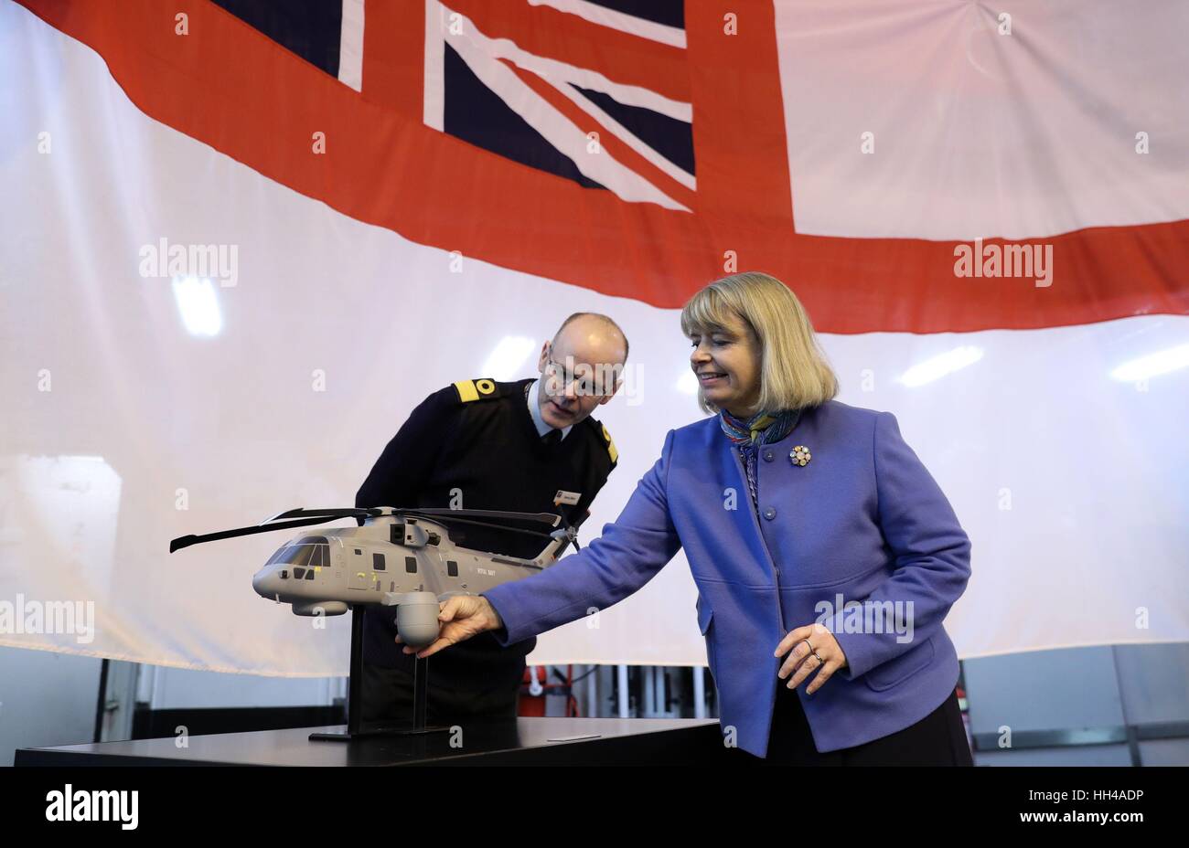 Minister for Defence Procurement Harriett Baldwin (right) and Commodore Steve Allen, Royal Navy, Assistant Chief of Staff Aviation, look at a model of a Merlin helicopter with the CROWSNEST Airborne Early Warning system fitted, on board HMS Dragon - a Type 45 Air Defence Destroyer - at Portsmouth Naval Base, where an announcement for a multi-million pound deal for a new cutting-edge helicopter-borne surveillance system designed to protect Royal Navy ships including the new Queen Elizabeth-class aircraft carriers was made. Stock Photo