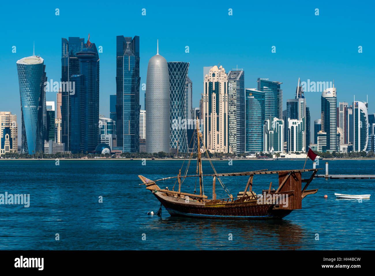 Dhow traditional sailing vessel with the financial area skyline behind, Doha, Qatar Stock Photo