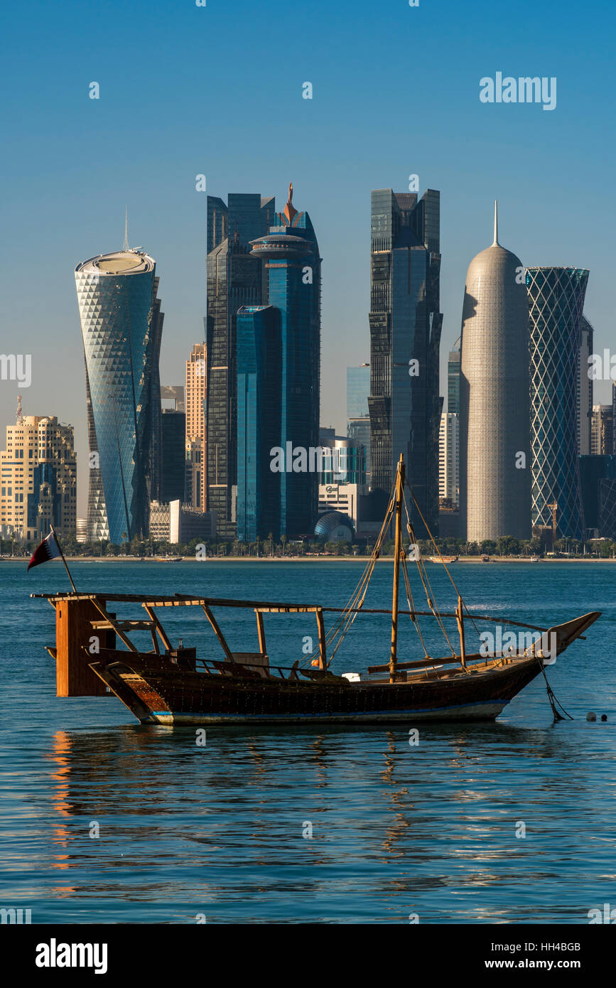 Dhow traditional sailing vessel with the financial area skyline behind, Doha, Qatar Stock Photo