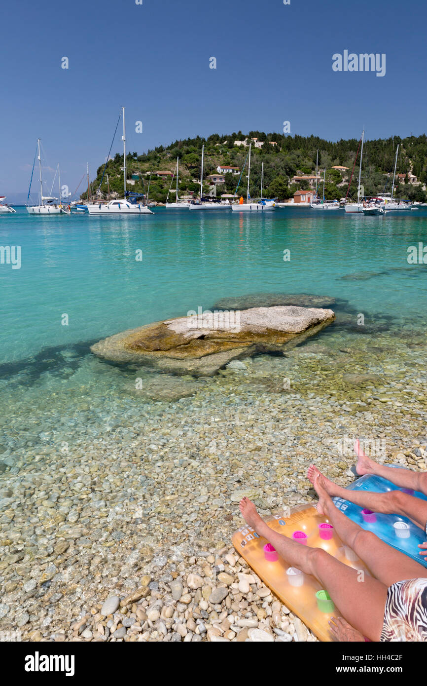 Sunbathers and yachts anchored in bay, Lakka, Paxos, Ionian Islands, Greek Islands, Greece, Europe Stock Photo