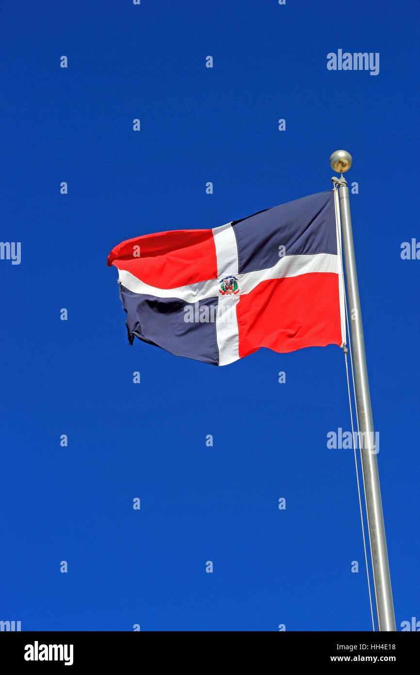 National flag of Dominican Republic flying against a blue sky Stock Photo