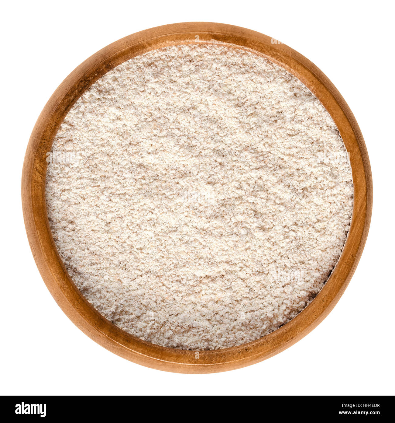 Wholewheat flour in wooden bowl. Wholemeal flour, a powdery substance