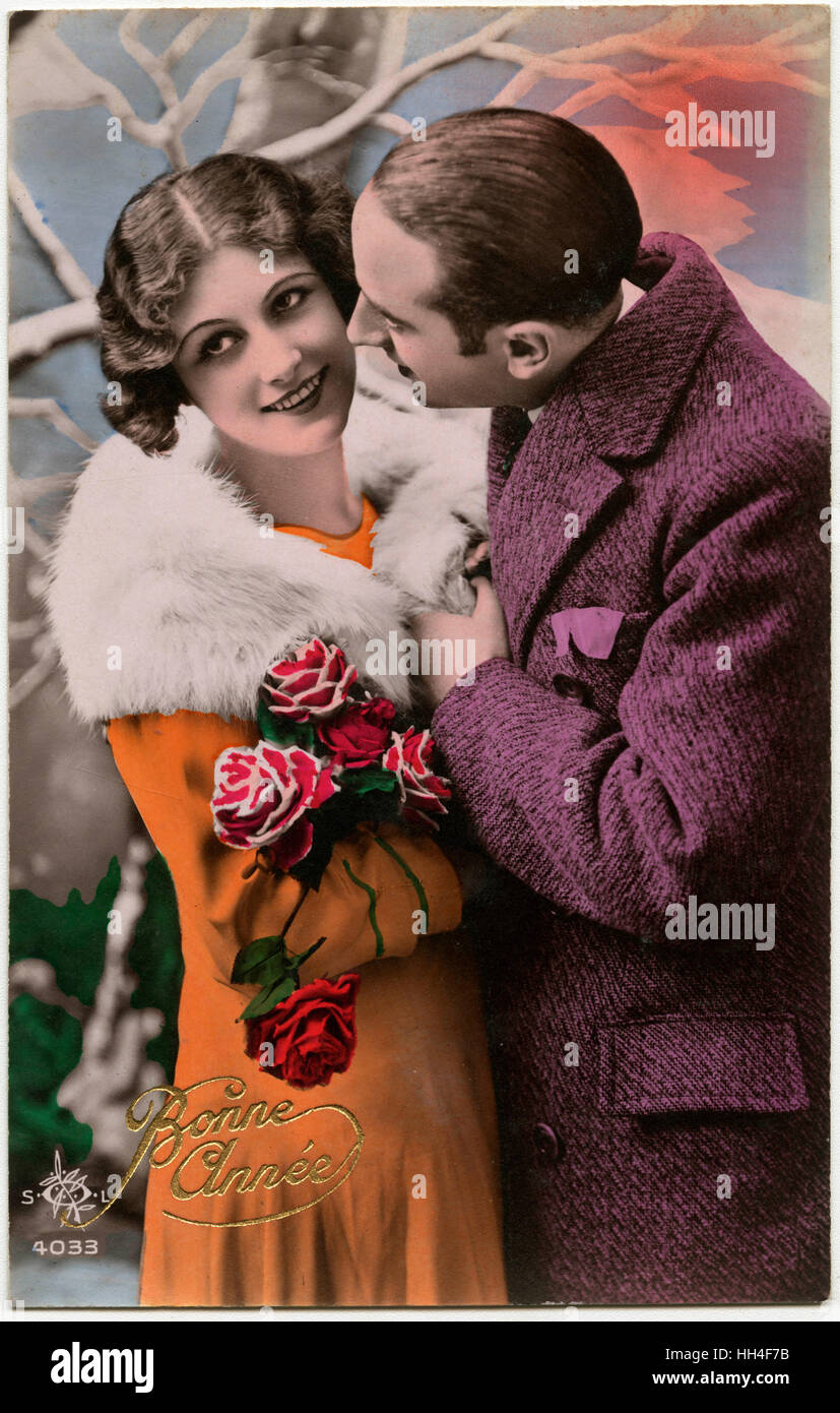 Kitsch New Years Greetings postcard featuring a young couple. Stock Photo