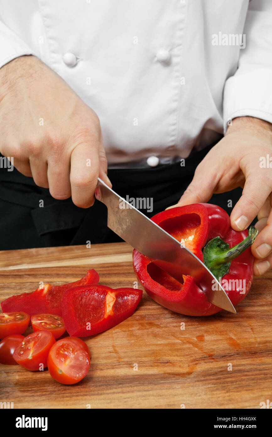 Photo of a chef chopping a red bell pepper on a wooden cutting board Stock Photo Alamy