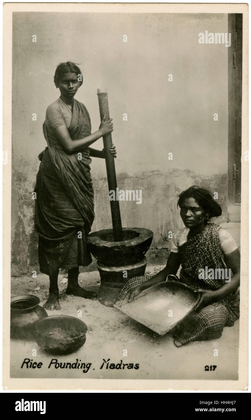 Pounding Rice using large pestle and mortar - Chennai, India Stock Photo