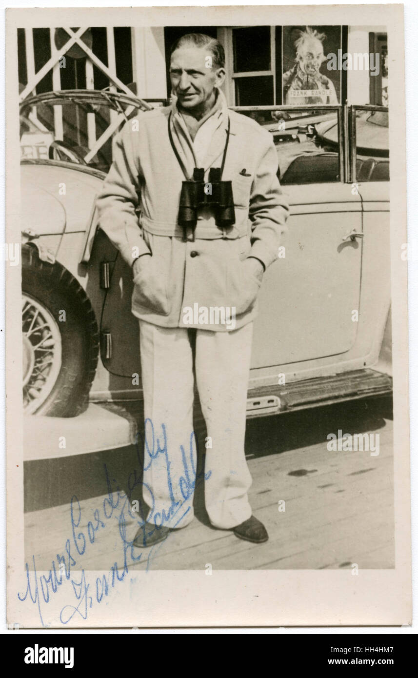 Signed photograph of Frank Randall - English Comedian (1901-1957), wearing binoculars and posing by a fine white open-top car outside a theatre where he was performing his most famous stage characterisation of 'The Old Hiker'. Stock Photo