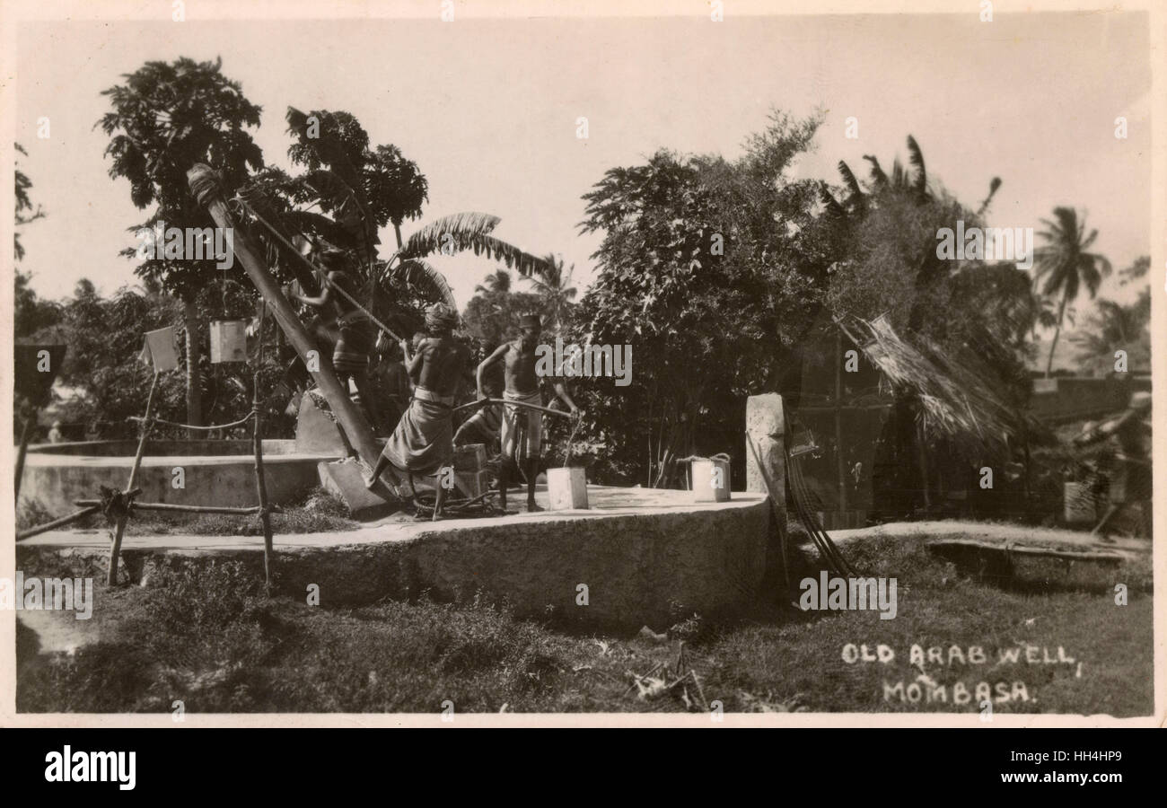 Old Arab well, Mombasa, Kenya, East Africa, with men drawing water. Stock Photo