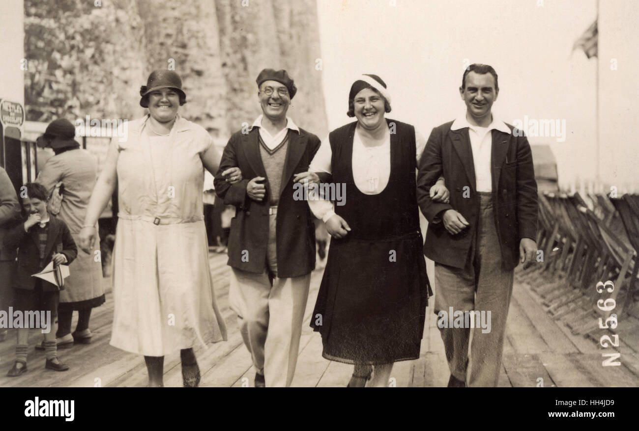 A jolly quartet of friends, arms linked for a photograph, while on holiday  in Margate in the 1930s. The chaps are in casual wear (defined by the open  collars and sporty knitwear),