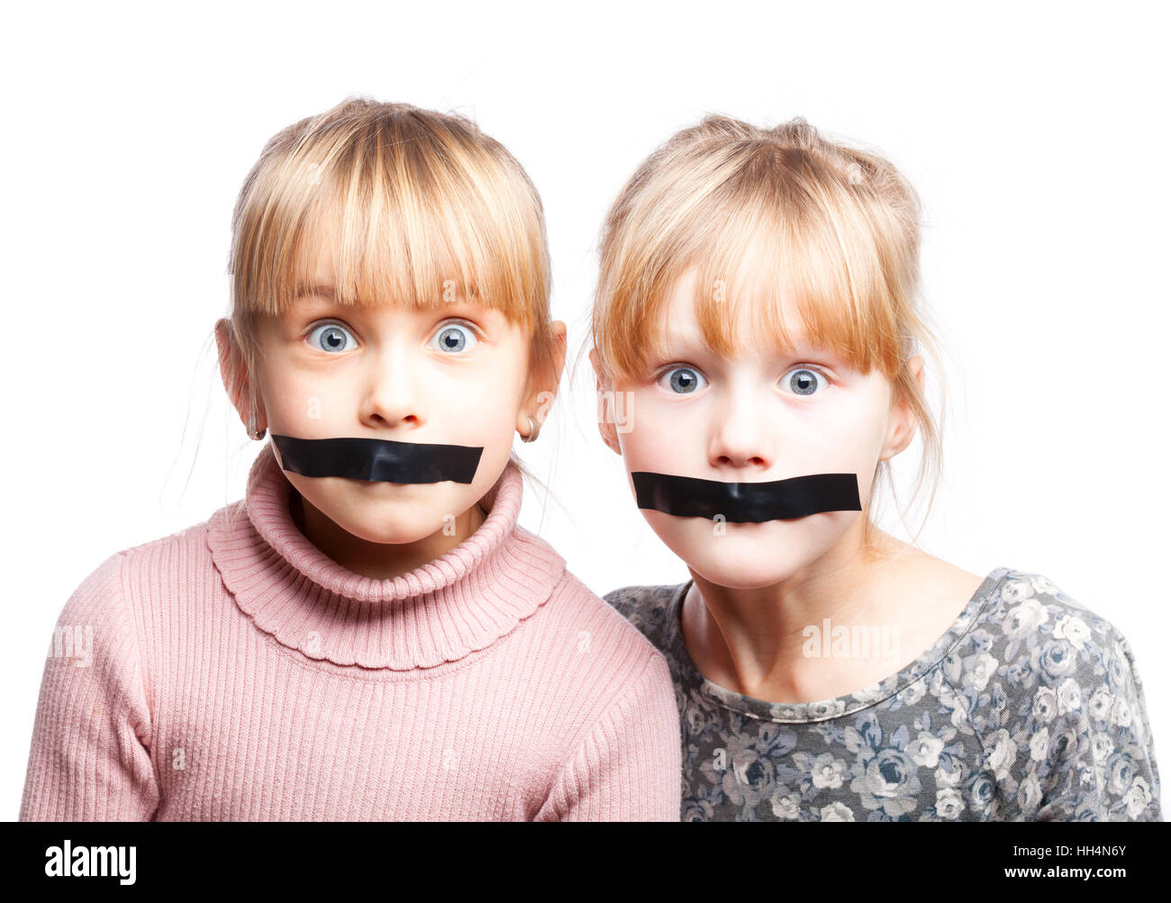 Portrait of two little girls with duct tape on their mouths silenced