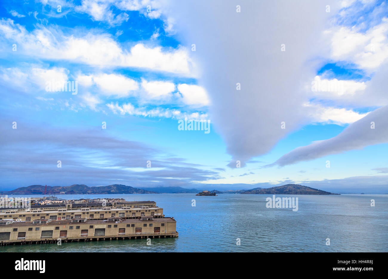 Alcatraz Prison Beyond San Francisco Piers Under Nice Clouds Stock Photo
